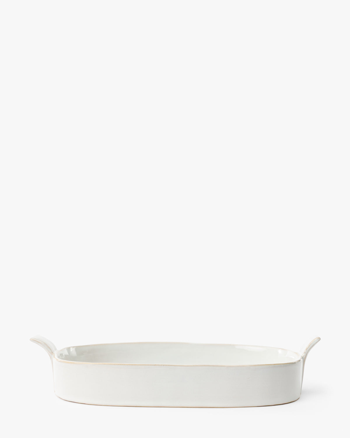 The 1.5 Quart Stoneware Baker is a white ceramic oval dish with two side handles, ideal for oven-to-table serving and shown on a plain white background by Vendixs