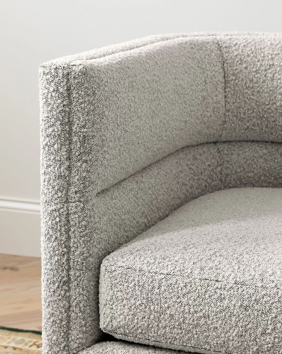 Close-up of the Makerspalm Claremont Modular Sofa 99 in light gray, featuring textured customizable fabric, plush cushioning, and clean lines where the seat, backrest, and armrest meet. Vendixs