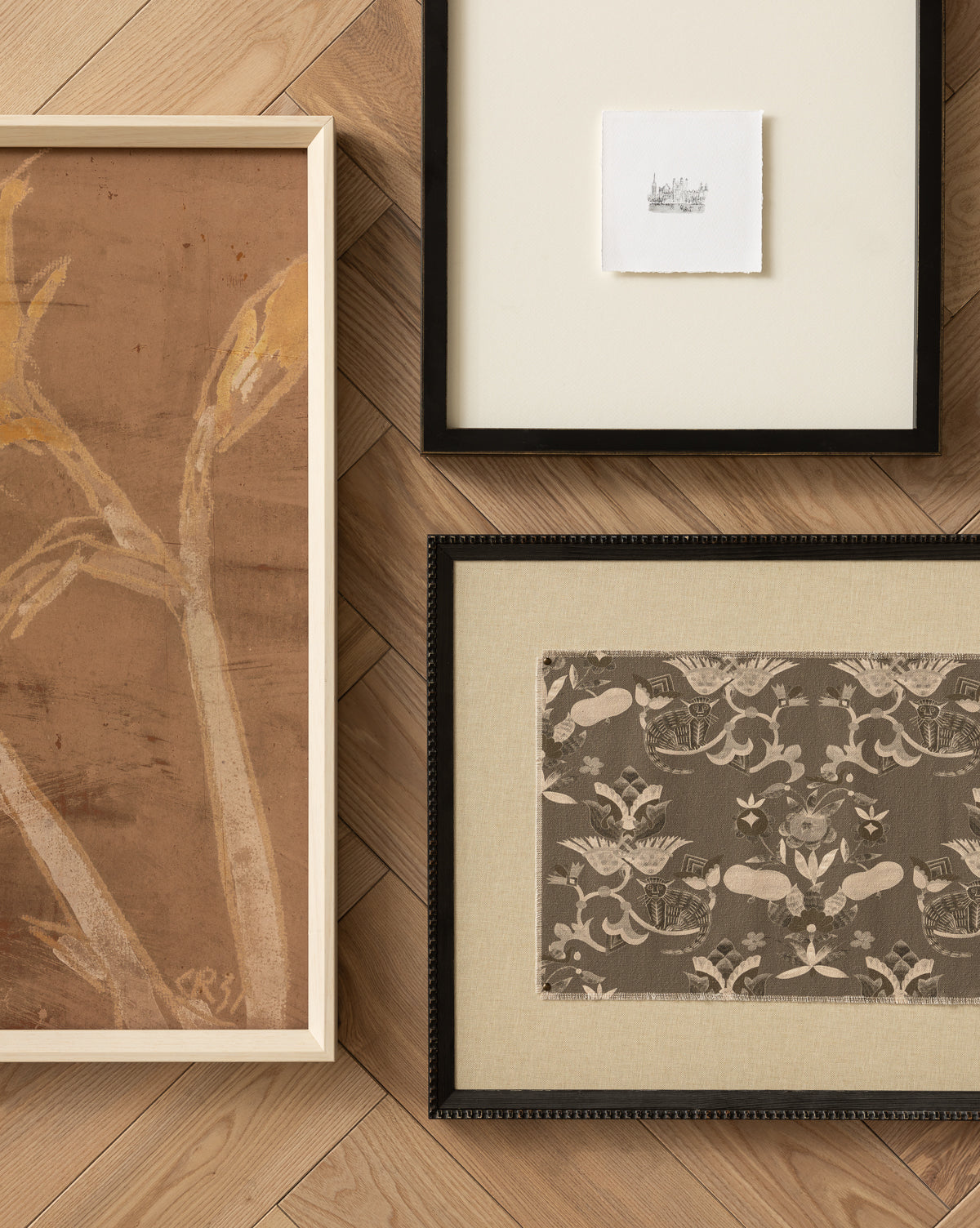Past Petals, a framed abstract plant artwork in a white wood frame, sits on a light herringbone floor alongside a wide-matted sketch and a floral patterned fabric—ideal as the perfect home accent, by Vendixs