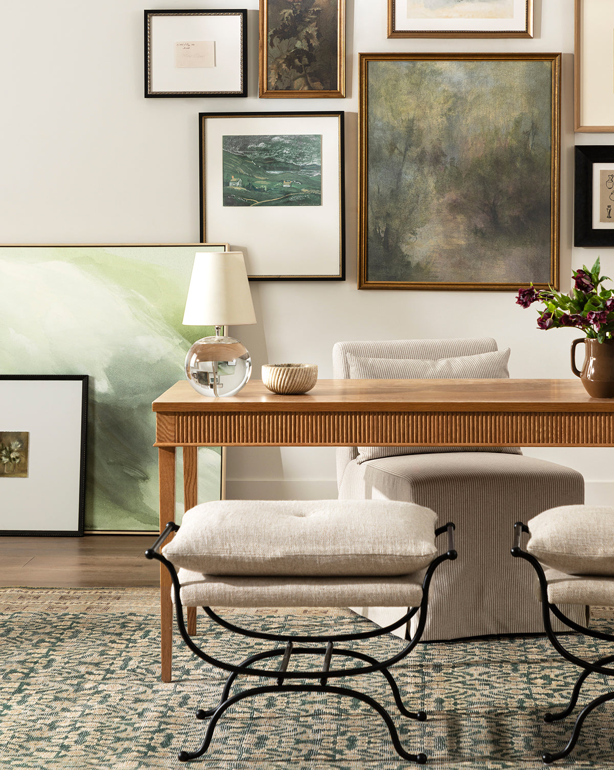 A stylish living room features a wooden desk, cushioned stools, and a table lamp. The Dream State museum-quality canvas art adds drama to the cozy space, while a patterned rug and vase of flowers enhance its texture and color by Vendixs