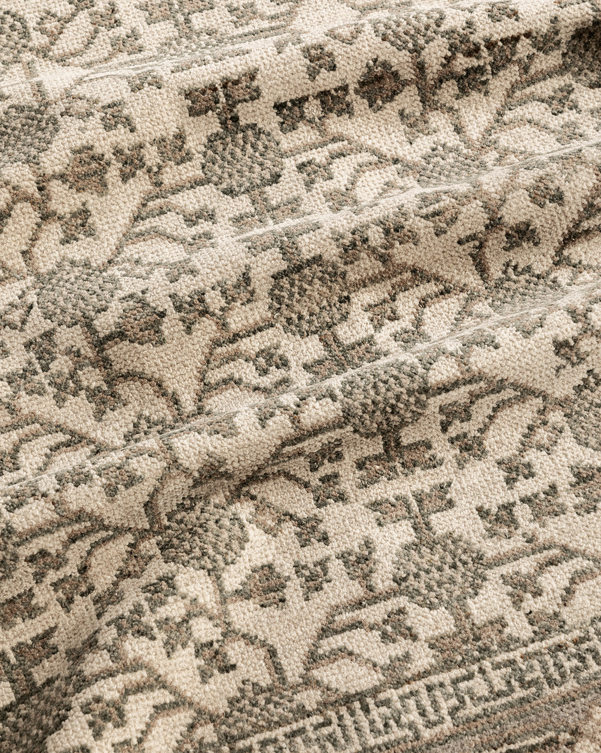 A close-up of the Orsino Hand-Knotted Rug highlights its beige background, intricate gray floral and geometric patterns, soft texture, and detailed craftsmanship, by Vendixs