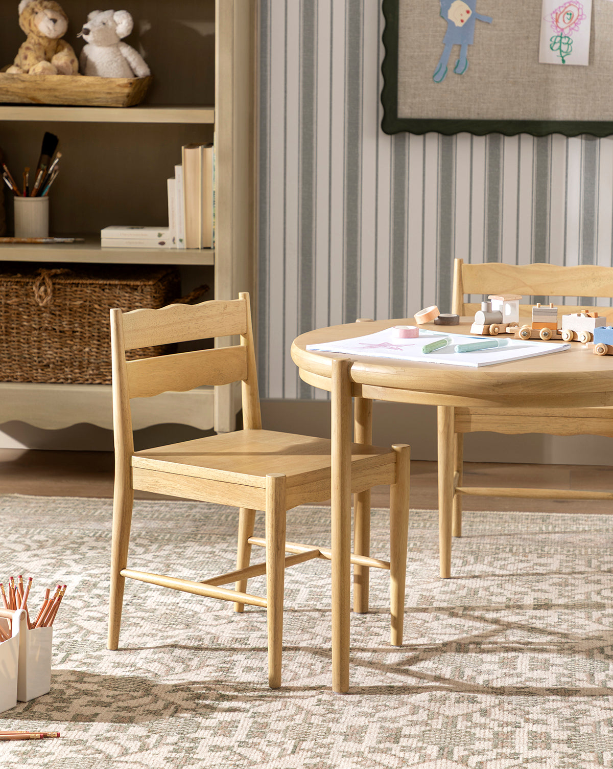 A light wood chair and table with art supplies sit on the Orsino Hand-Knotted Rug in a cozy children’s room, with shelves displaying toys, baskets, and wall art in the background, by Vendixs