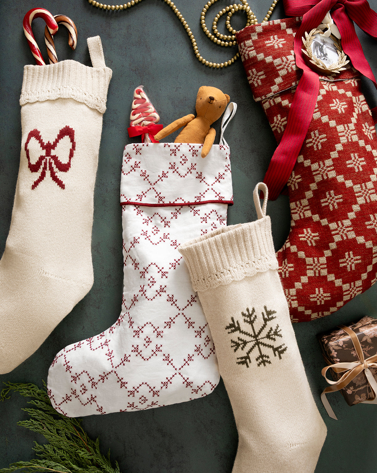 The Bella Scalloped Stocking with Snowflake, filled with candy canes and a small teddy bear, makes for perfect cozy holiday mantel decor, by Vendixs