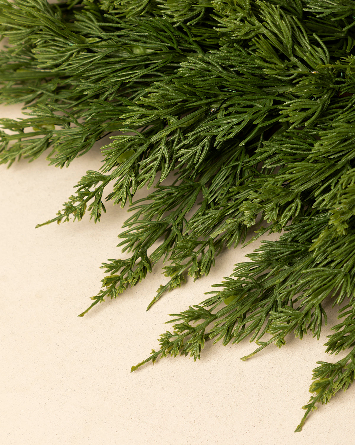 A close-up of fresh dill sprigs with feathery green leaves on a light beige surface—perfect to inspire natural holiday décor or to pair with the 30" Classic Cedar Pre-Lit Faux Wreath for a festive accent, by Vendixs