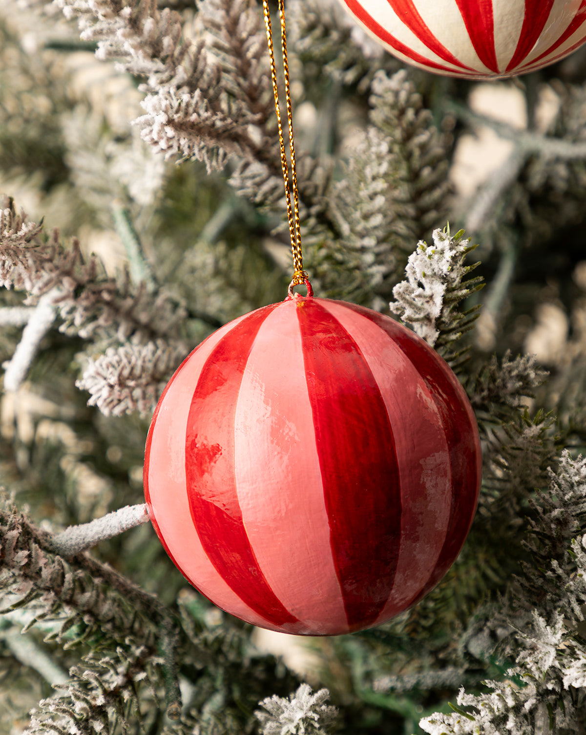 A set of three 3" hand-painted paper mache baubles with tassels, featuring red and pink stripes, hangs from gold strings on your Christmas tree, bringing festive charm to your holiday decor, by Vendixs