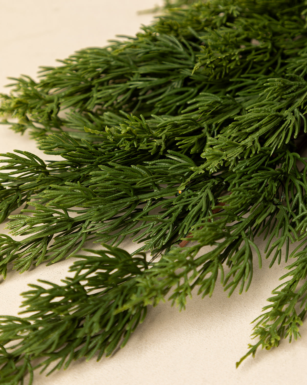Close-up of fresh, green dill sprigs with feathery leaves on a light surface—perfect inspiration for holiday home decor or for accenting your 6' Cedar Pre-Lit Faux Garland, by Vendixs