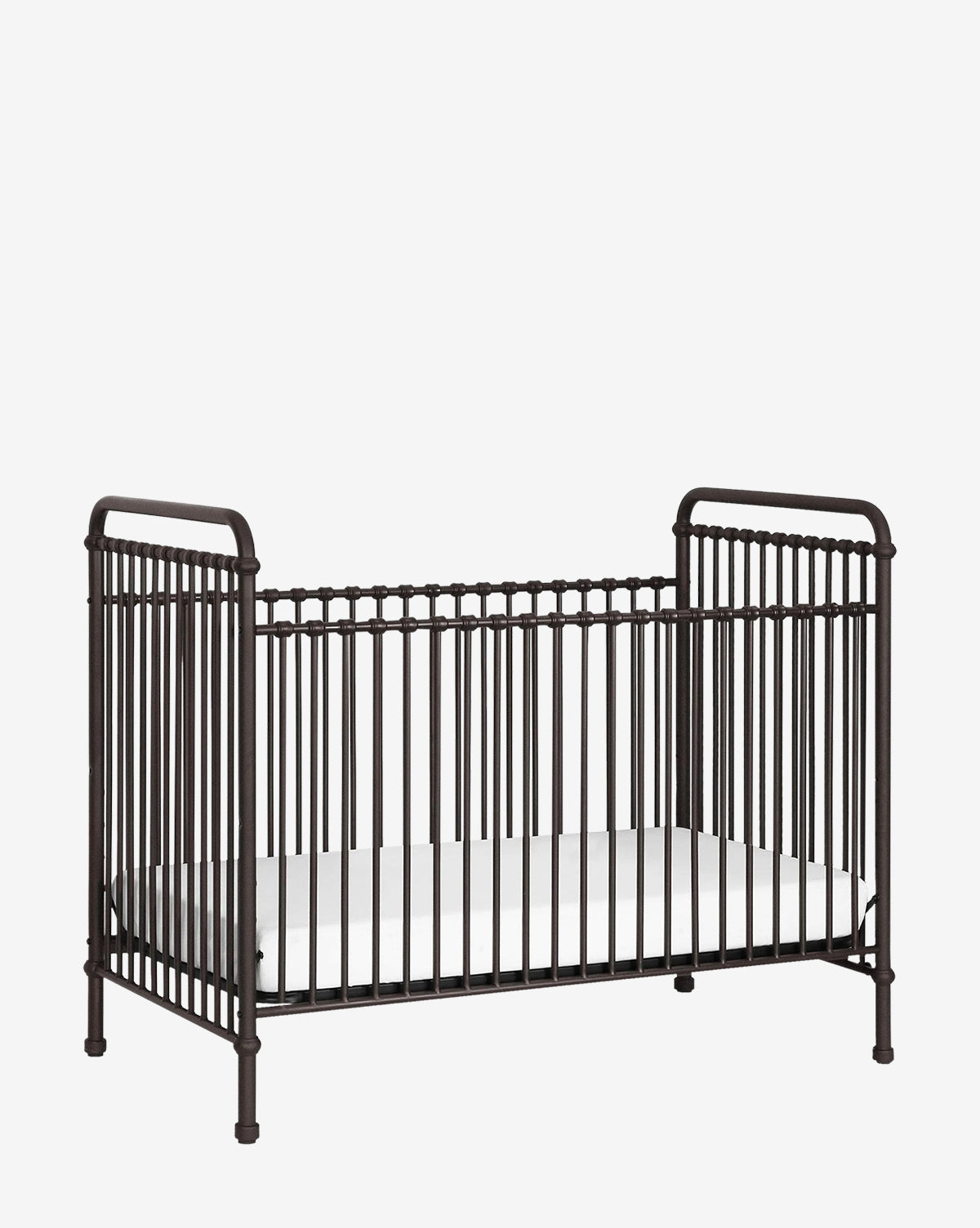 The Abigail 3-in-1 Convertible Crib by Million Dollar Baby features dark metal, vintage-style vertical bars and a white mattress, creating a timeless nursery look that stands out against a plain white background. Vendixs
