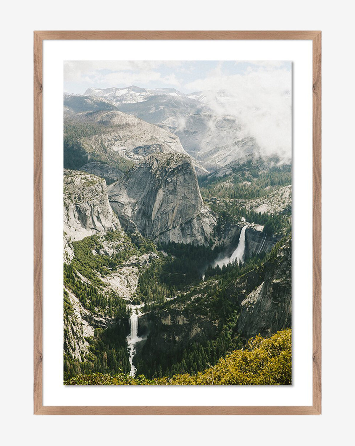 Above The Clouds by Wesley and Emma Teague: A framed photo of granite cliffs, lush forest, a river, and two waterfalls under a partly cloudy sky in a walnut-finished wood frame by Vendixs