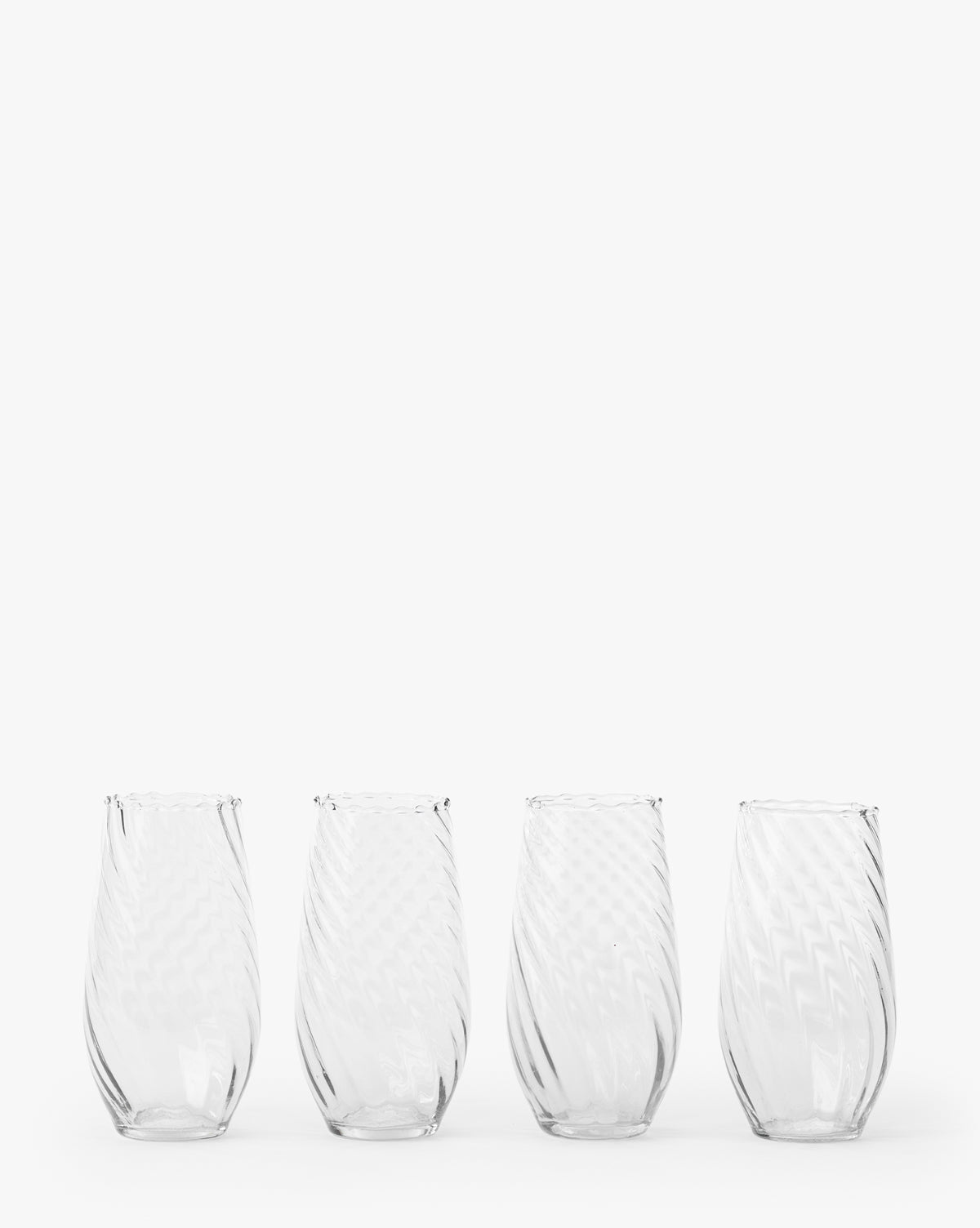 The Adderley Highball Glasses (Set of 4) feature clear, stemless designs with a subtle swirling pattern, crafted from mouth-blown glass and arranged in a row against a plain white background by McGee & Co.