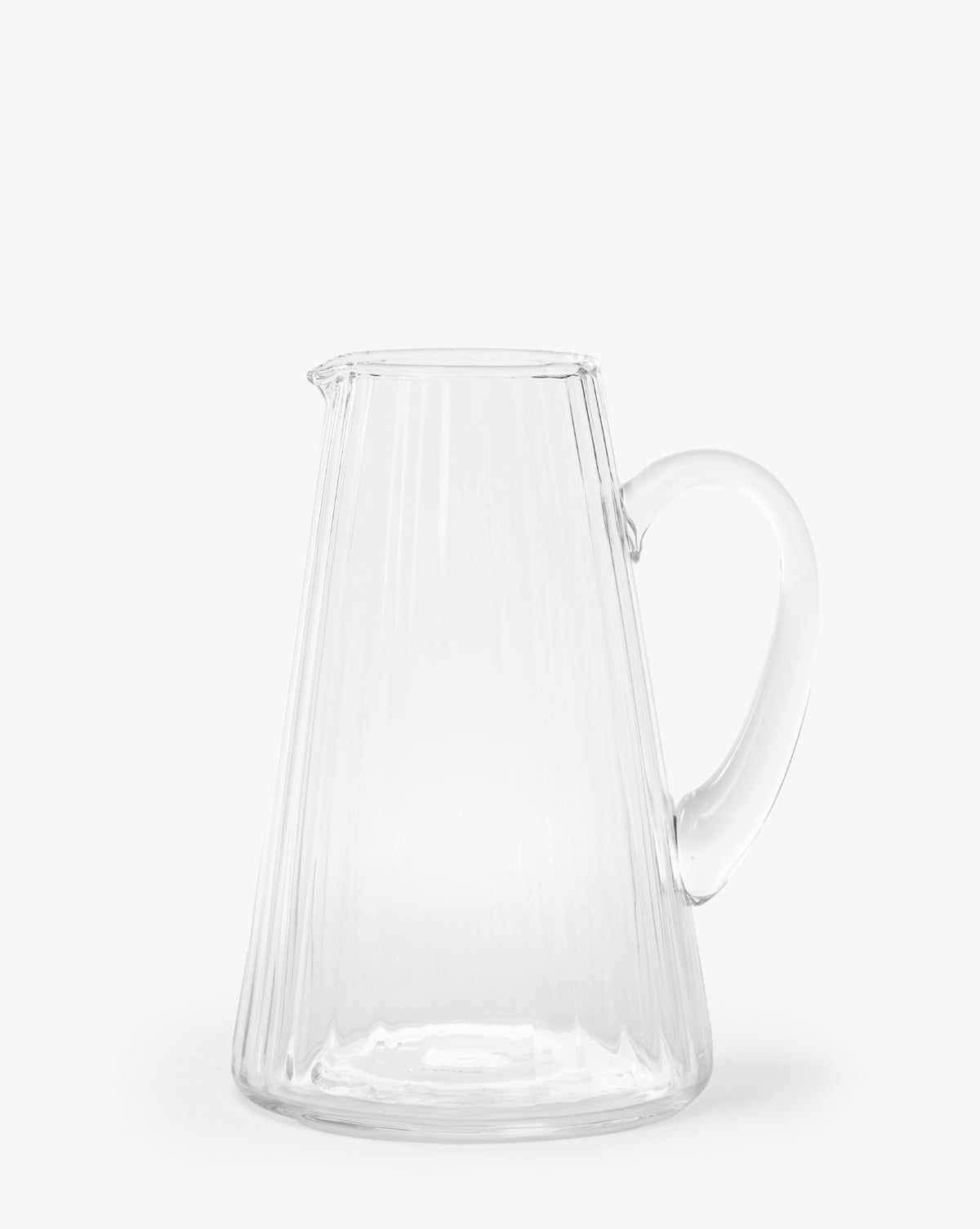 The Adonis Ribbed Glass Pitcher, featuring a wide base, narrow top, and curved handle, brings elegant style to any kitchen decor and is shown here against a plain white background by McGee & Co.