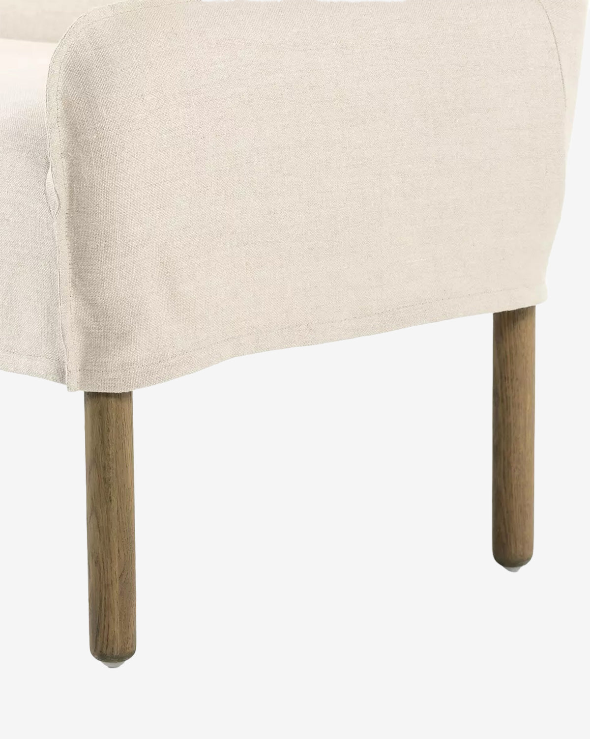 The Aiken Slipcover Bench features beige linen upholstery, a simple curved backrest, and visible wooden legs, by McGee & Co. Its cushioned seat provides added comfort, complementing the bench’s clean design against a white background.