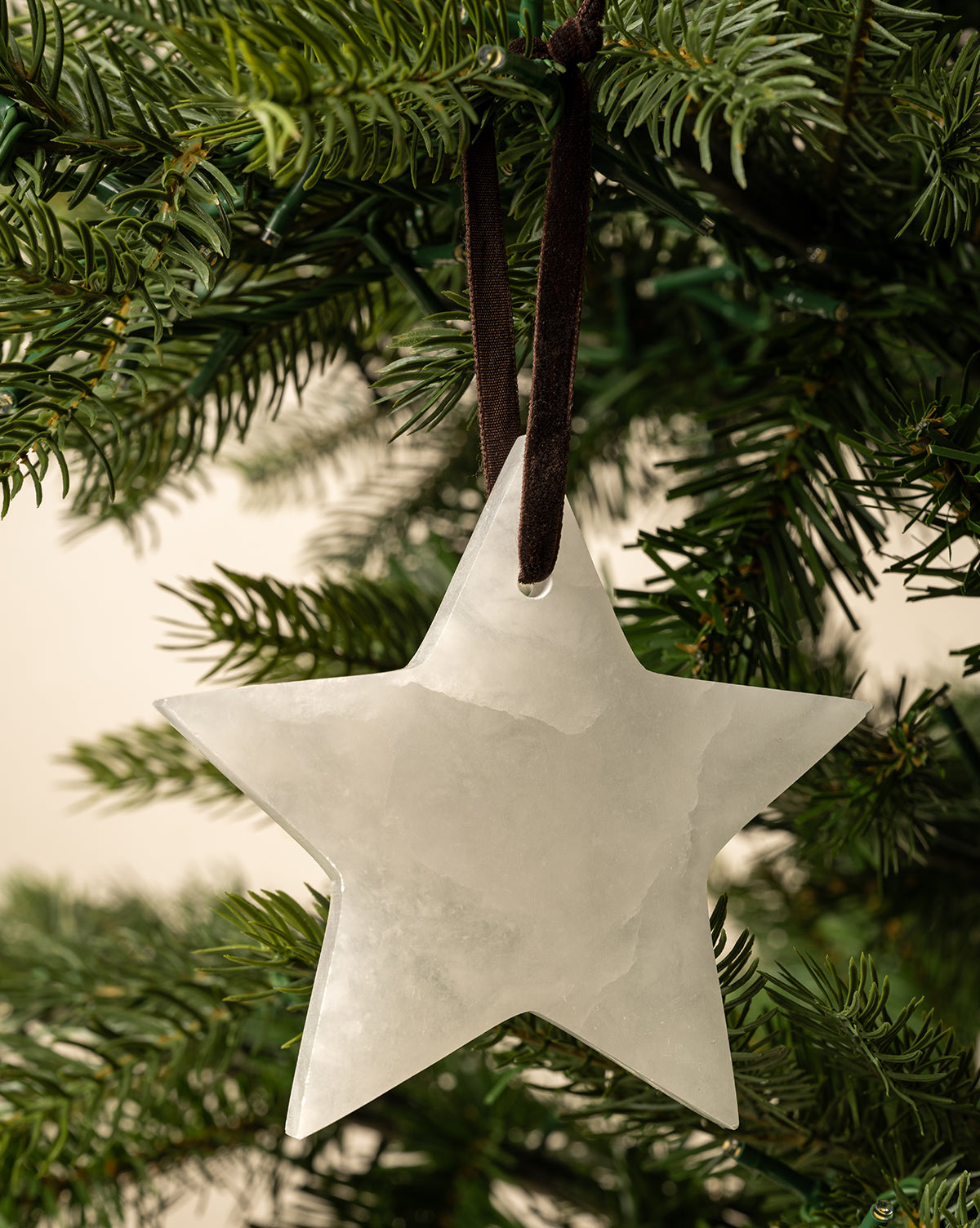 Alabaster Star Ornaments (Set of 2) hang from dark ribbons on your Christmas tree, adding a touch of elegance to your festive decor, by Vendixs