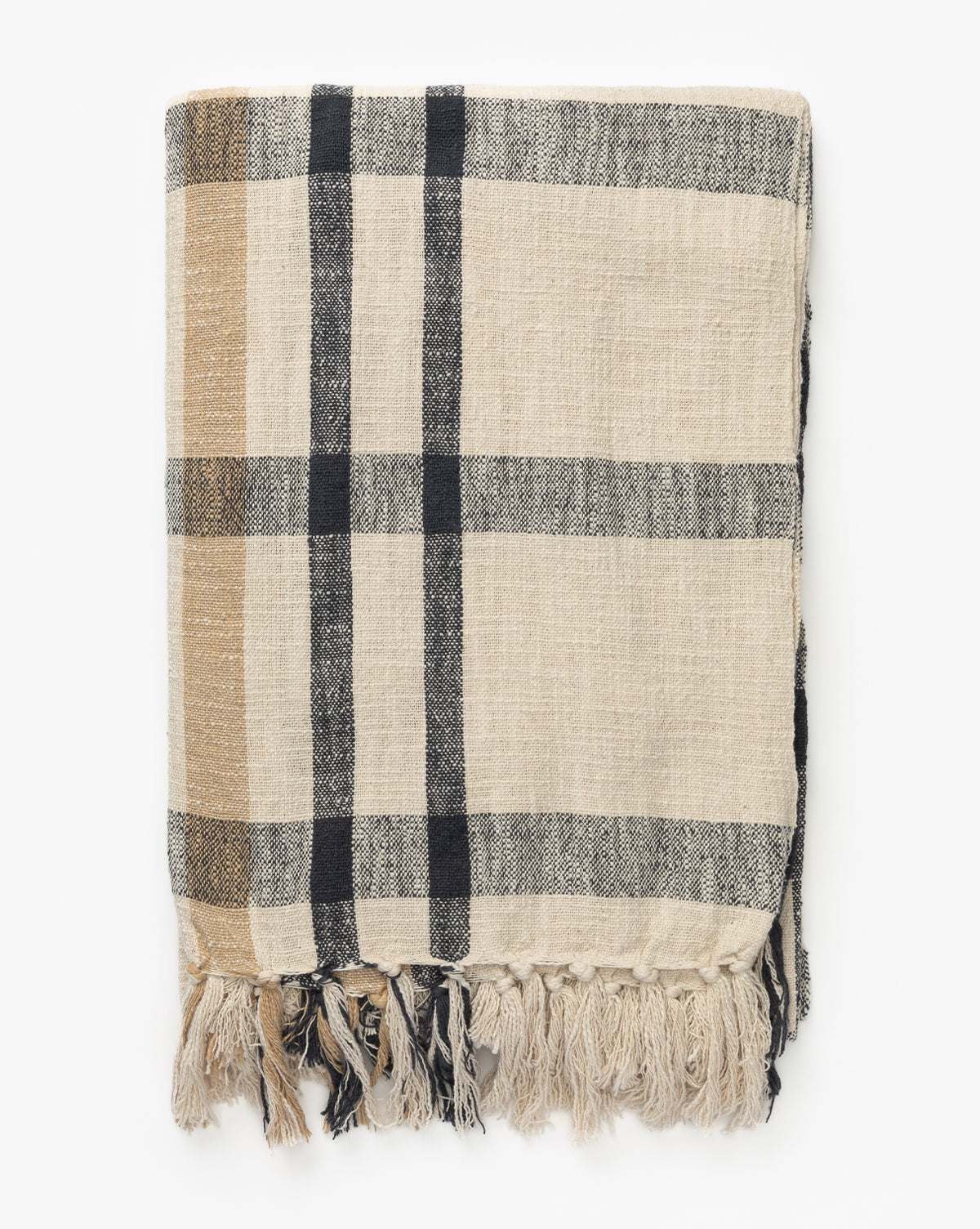 The Raj Albright Plaid Throw, beige cotton with black and tan plaid stripes and fringed tassels, is neatly folded on a white background, Vendixs