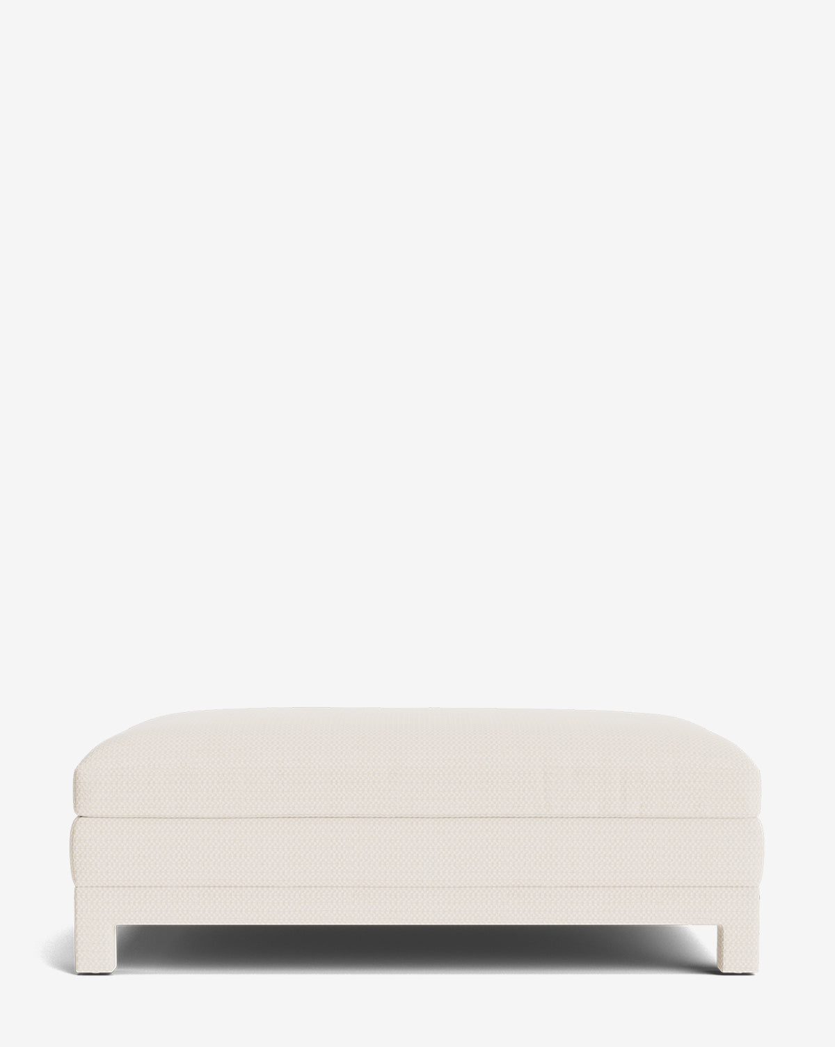 The Appoline Ottoman is a rectangular, low-profile piece in light cream with short legs and a smooth, cushioned surface for modern, stylish comfort. Upholstered and shown against a plain white background by McGee & Co.