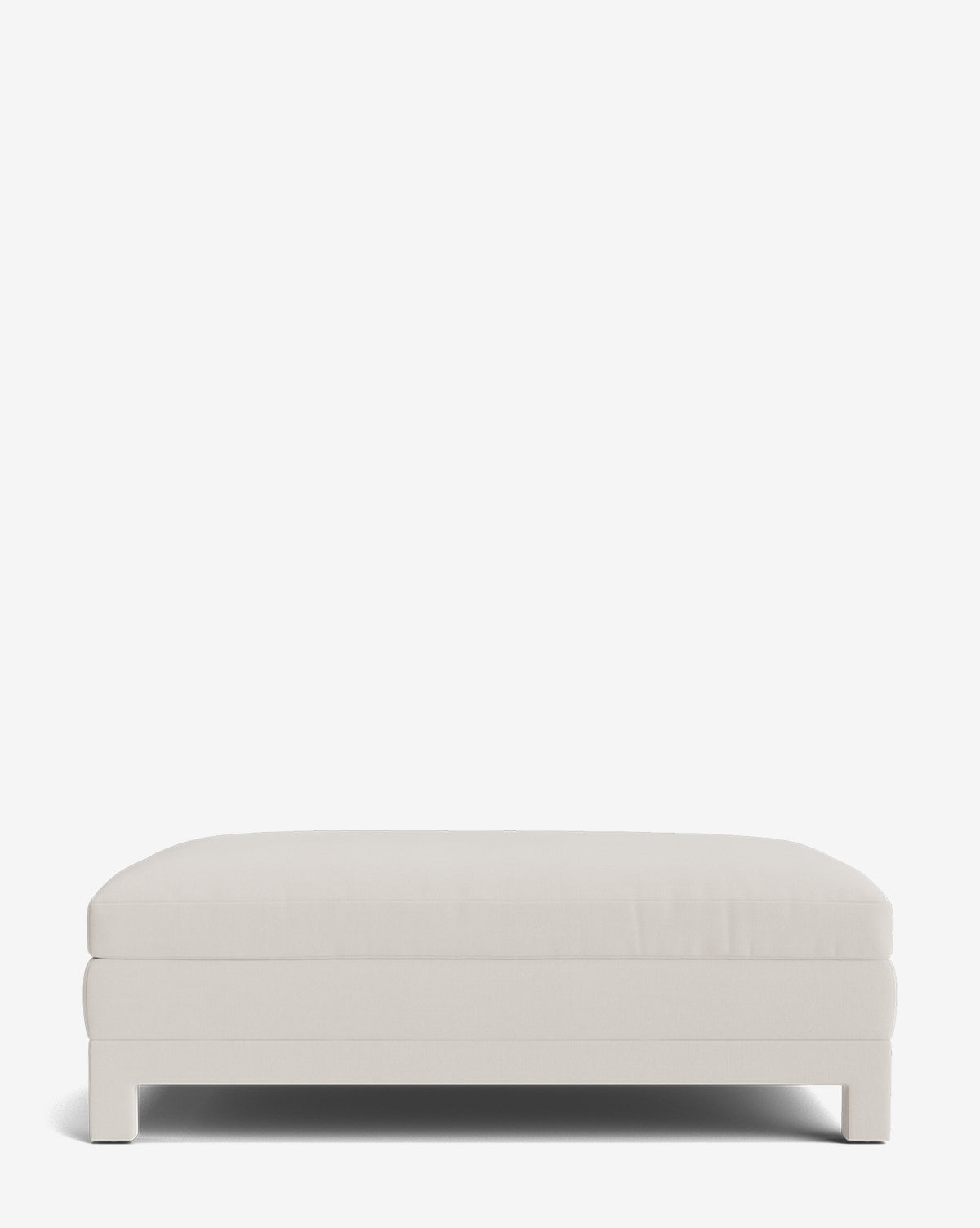 The Appoline Ottoman is a minimalist, rectangular piece made to order in light beige. Shown from the front against a white background, it features simple upholstery and short block legs for a sleek, modern look by Vendixs