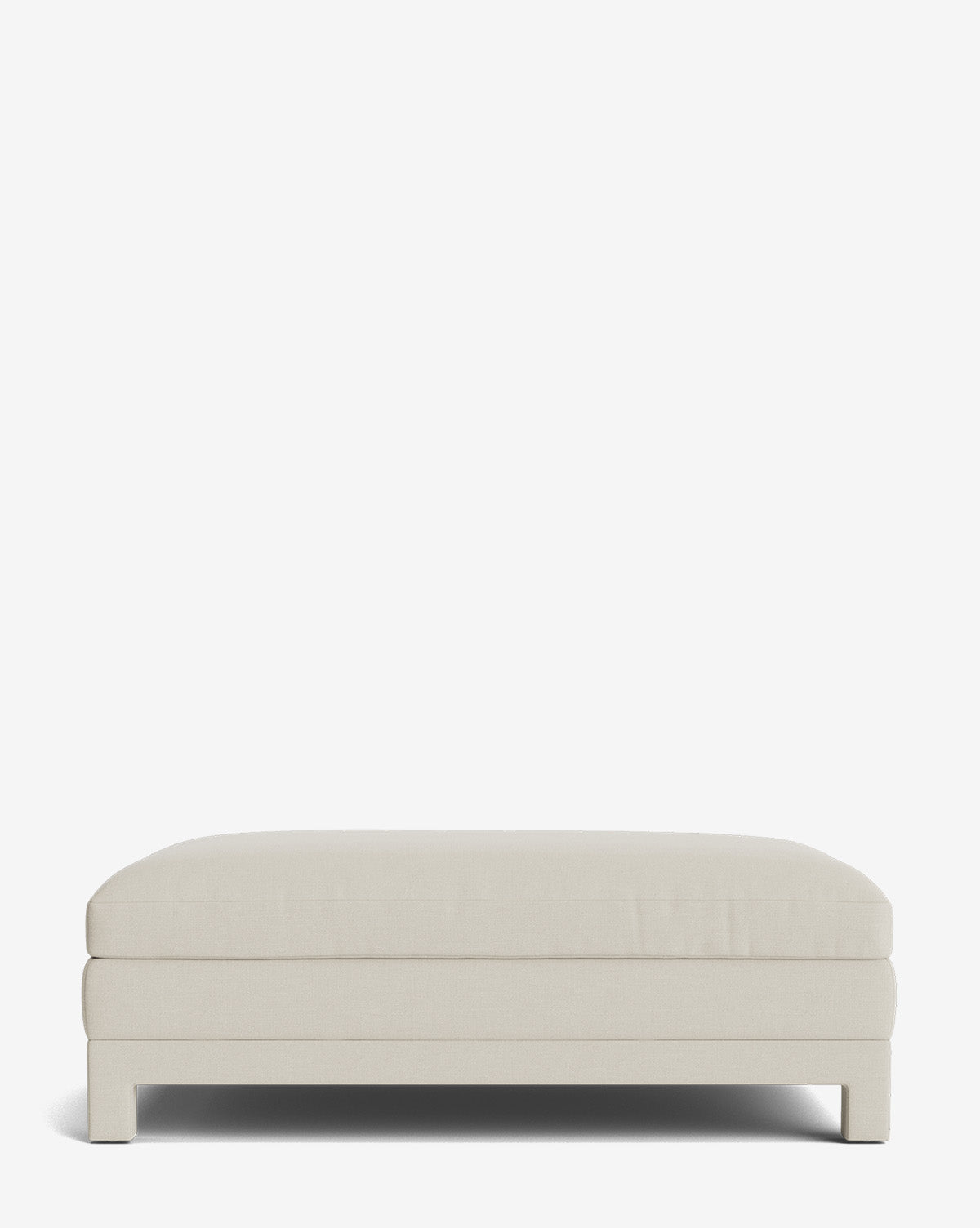 The Appoline Ottoman is a large rectangular piece with a cushioned top and simple modern wooden legs, shown from the front against a plain white background by McGee & Co.