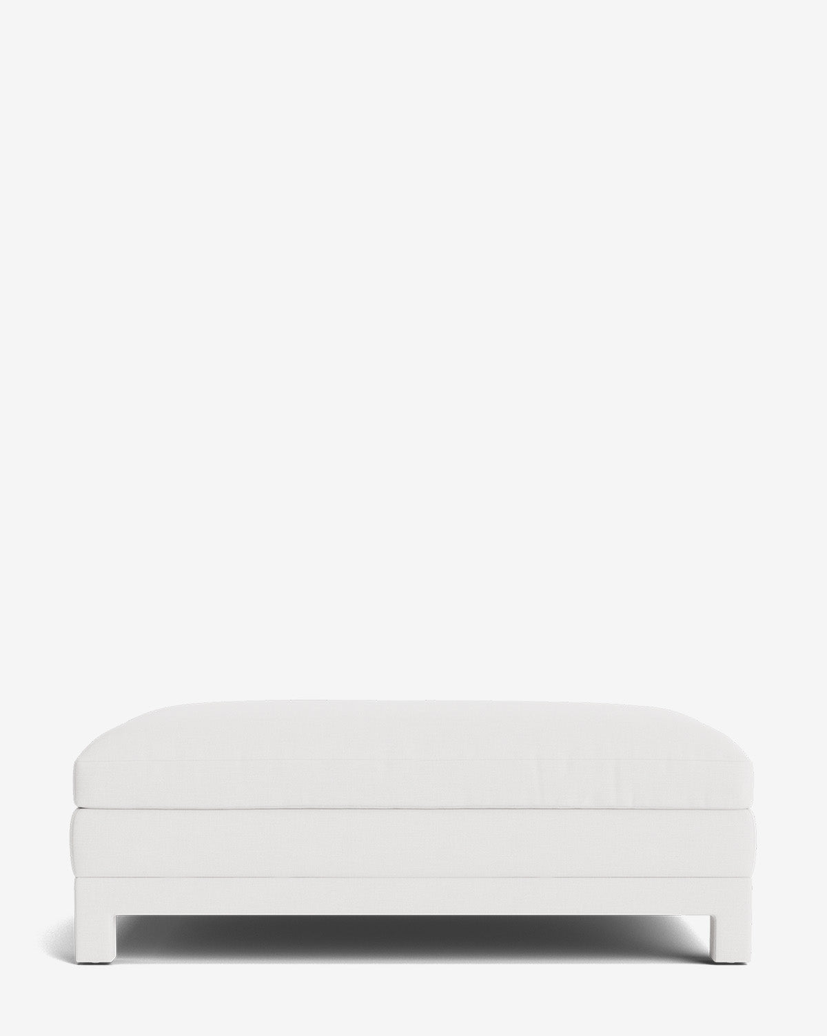 The Appoline Ottoman features a minimalist, modern design with a rectangular shape, low block-style legs, and crisp white upholstery, set against a plain white background by McGee & Co.