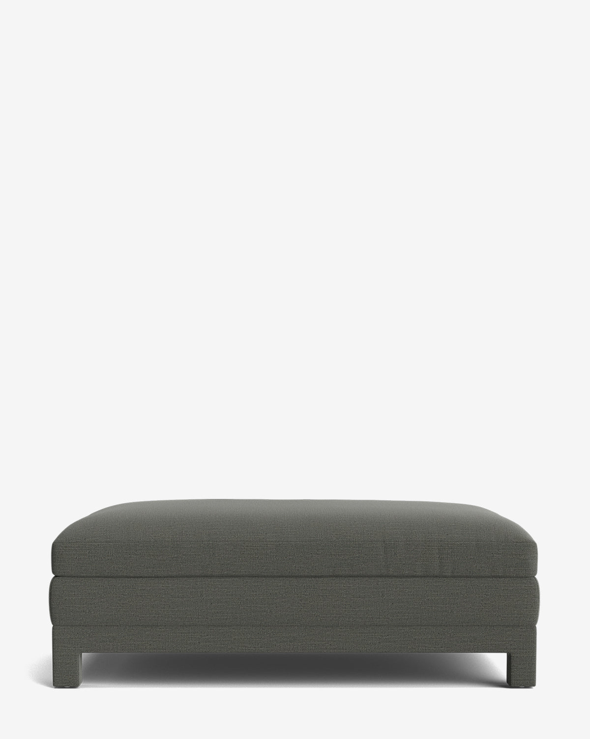 The Appoline Ottoman features dark gray upholstery, short legs, and soft, clean lines in a simple rectangular shape. Made to order, it’s perfect for contemporary spaces and is shown here against a white background by McGee & Co.