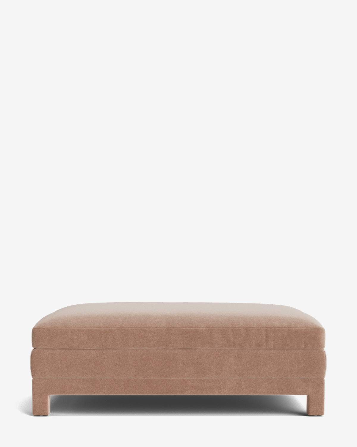 The Appoline Ottoman is a large, rectangular piece with a simple modern design and light brown upholstery. It sits on short legs against a plain white background, adding versatile style to any space by McGee & Co.
