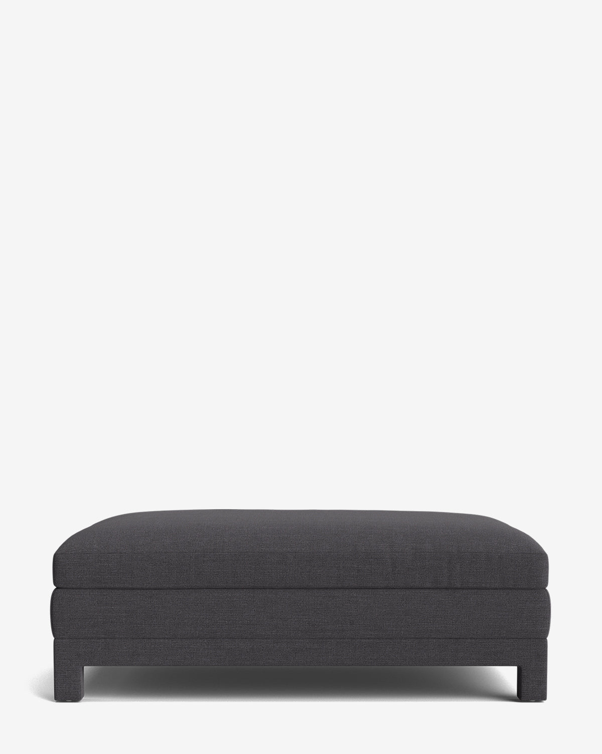The Appoline Ottoman is a modern, rectangular upholstered piece in dark gray, featuring a minimalist design and short block legs, shown against a plain white background by McGee & Co.