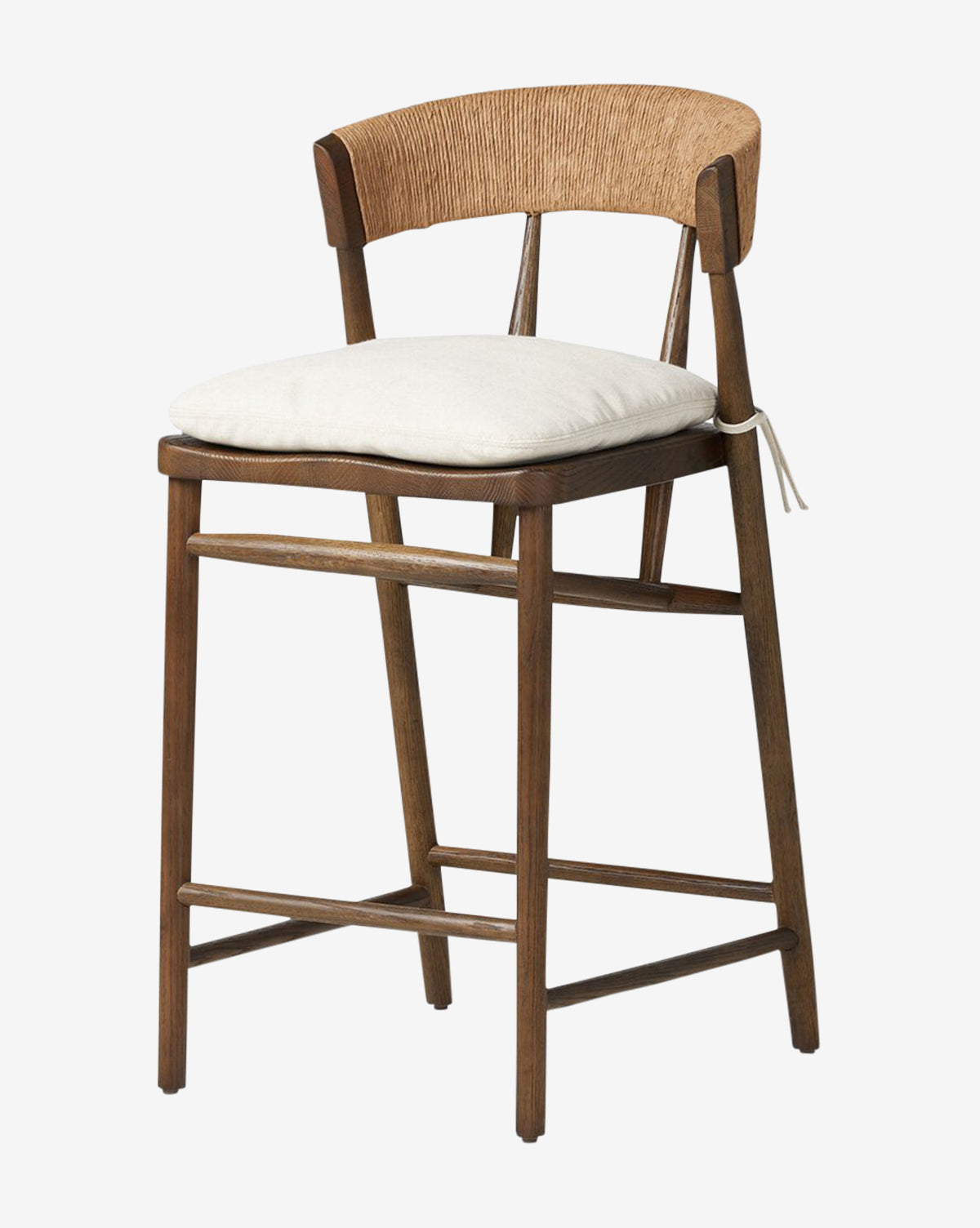 The Ardent Stool by Four Hands features a solid oak frame, curved backrest, woven rattan details, and a light cushioned seat—ideal for kitchen bars. Four sturdy legs with support bars ensure stability and style. Vendixs