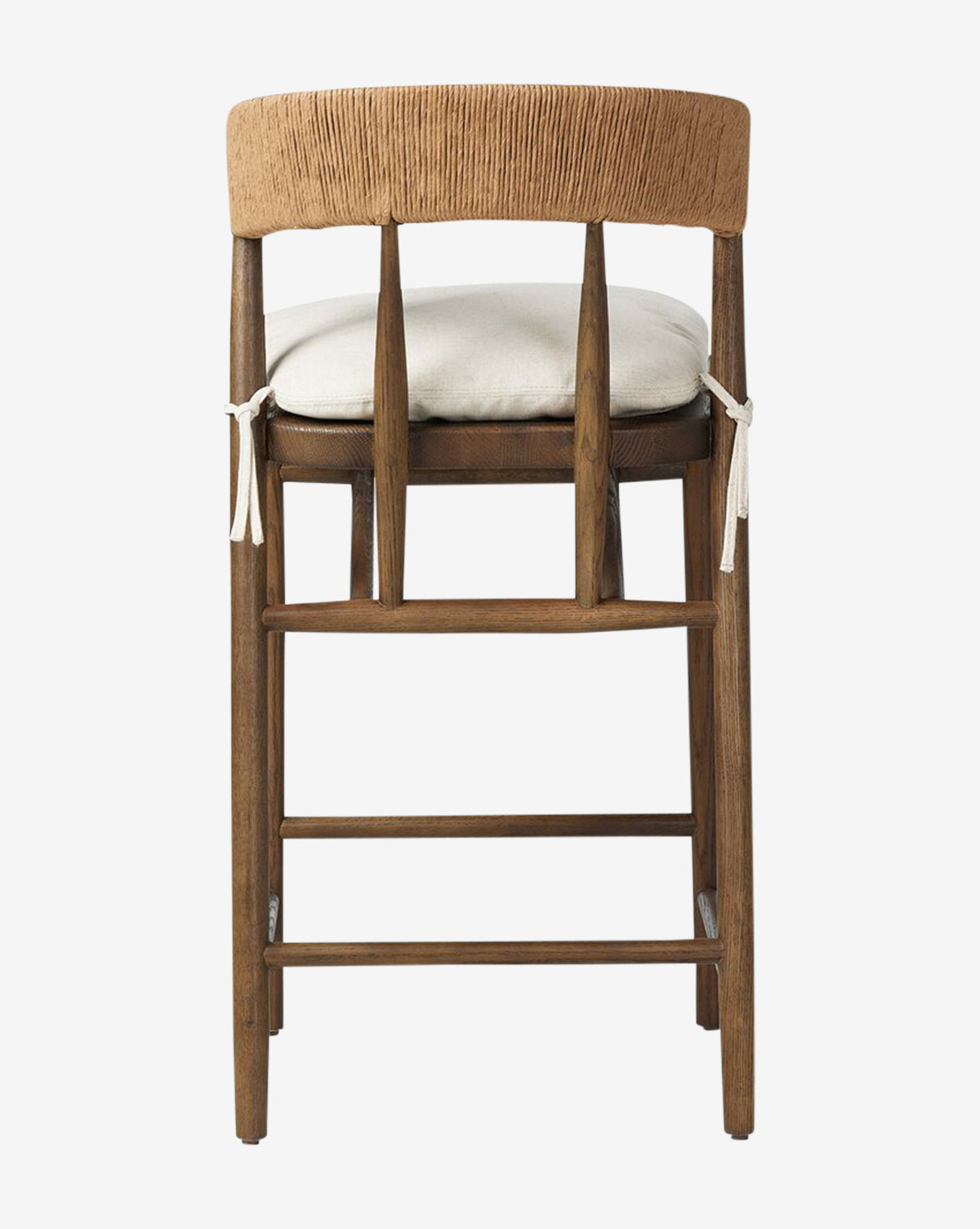 Back view of the Four Hands Ardent Stool, showcasing a curved woven backrest with vertical slats, a light cushioned seat with white ties, and a solid oak frame in a rustic natural finish—ideal for your kitchen bar. Vendixs
