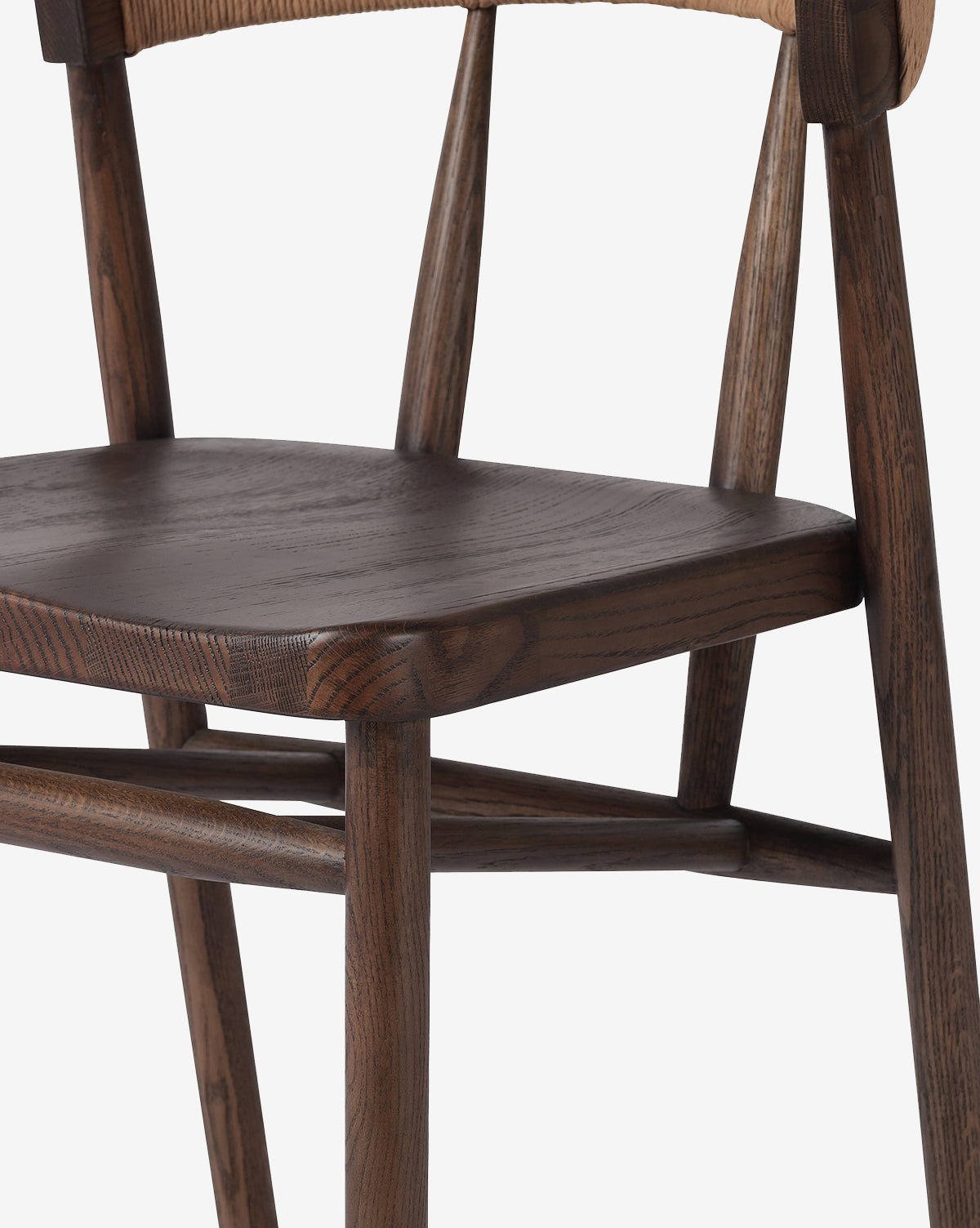 Close-up of the Four Hands Ardent Stool showcases its solid oak frame, dark smooth seat, angled legs, and curved backrest. The modern design and natural wood grain finish make it perfect for any kitchen bar setting. Vendixs