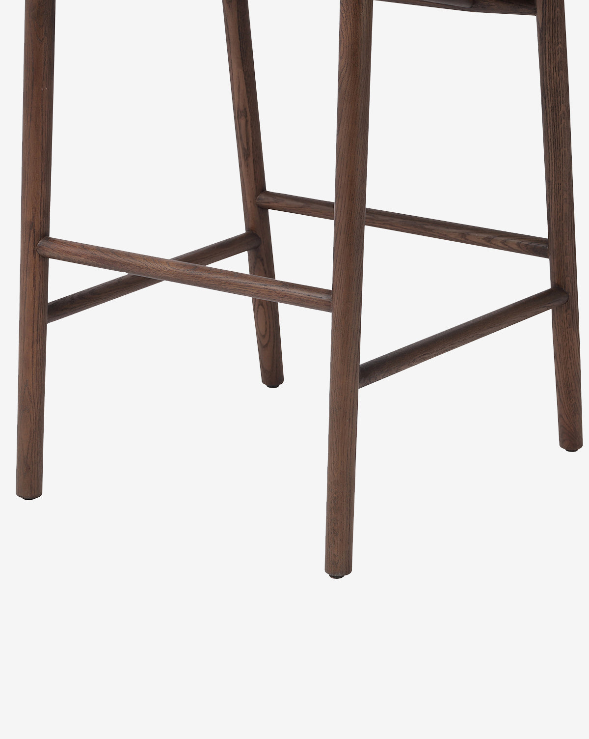Close-up of the Ardent Stool by Four Hands, highlighting its solid oak frame and footrest—an ideal addition to any kitchen bar, set against a plain white background. Vendixs