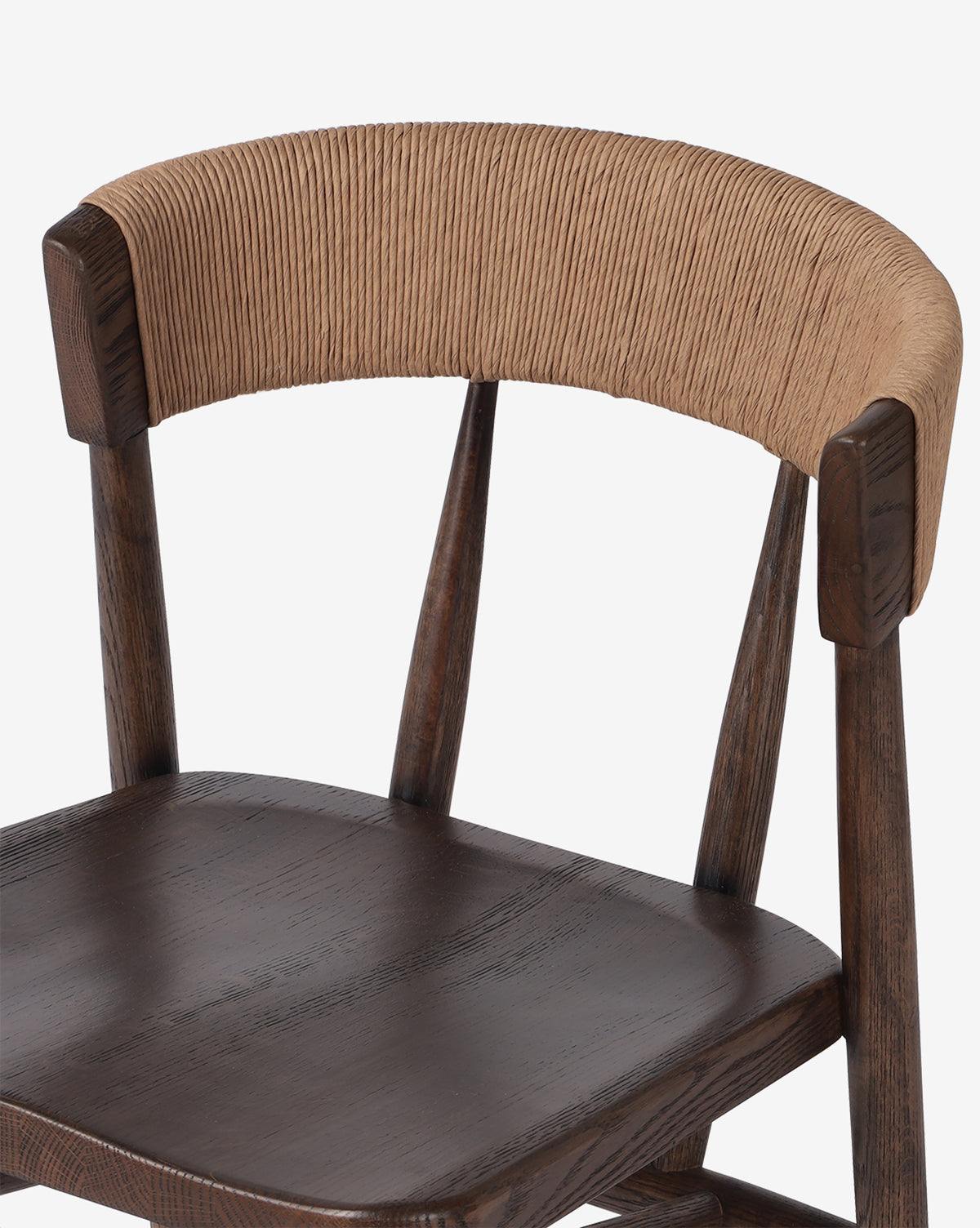 The Ardent Stool by Four Hands is a wooden kitchen bar stool with an oak frame, dark brown seat, and a curved backrest wrapped in natural paper rush for added texture and style by Vendixs