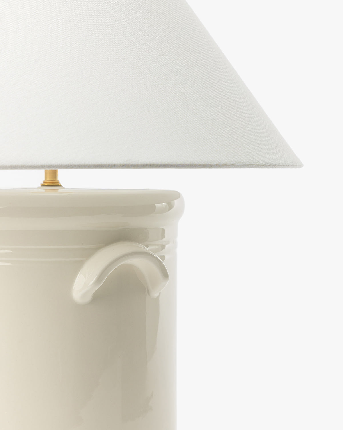 Close-up of the Arles Table Lamp, showcasing its glossy ceramic base with a small handle and a wide white fabric shade—perfect for enhancing your home lighting against a plain white background, by Vendixs