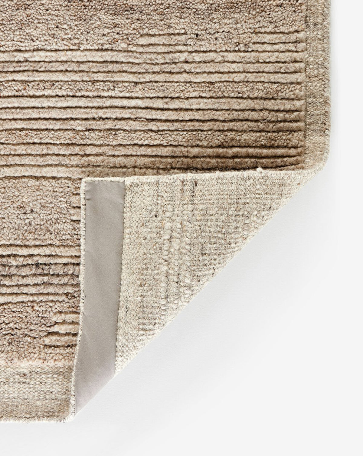 A corner is folded to show the woven underside and reinforced edge, emphasizing its quality craftsmanship and textured design, by Vendixs