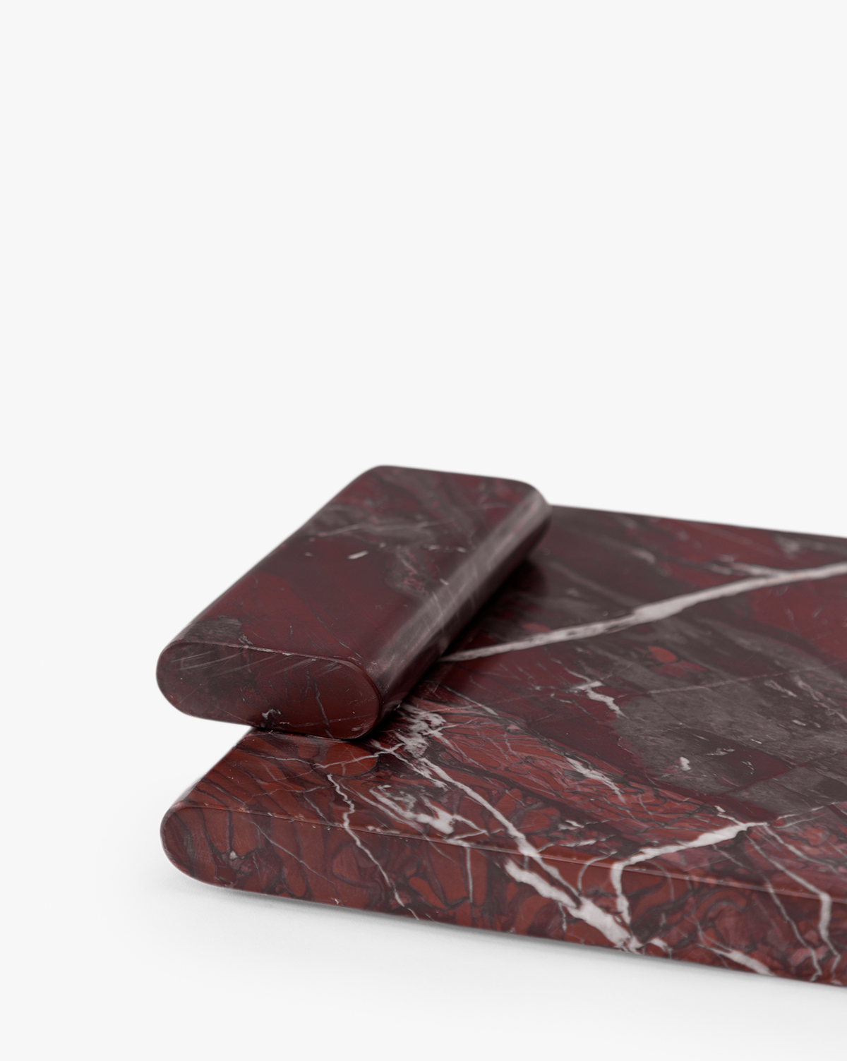 An Auburn Marble Tray with white veining patterns is displayed on a white background, accompanied by a matching dark red marble rolling pin, by Vendixs