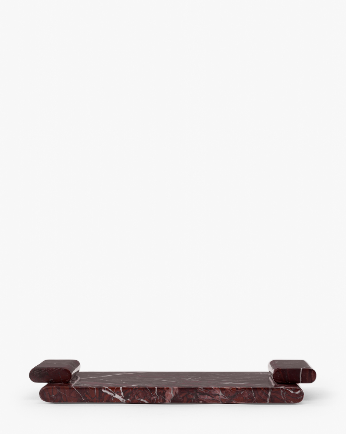 The Auburn Marble Tray is a low, rectangular tray crafted from auburn marble with white veining, rounded edges, and raised cylindrical ends, offering an elegant decorative accent against a plain white background, by Vendixs