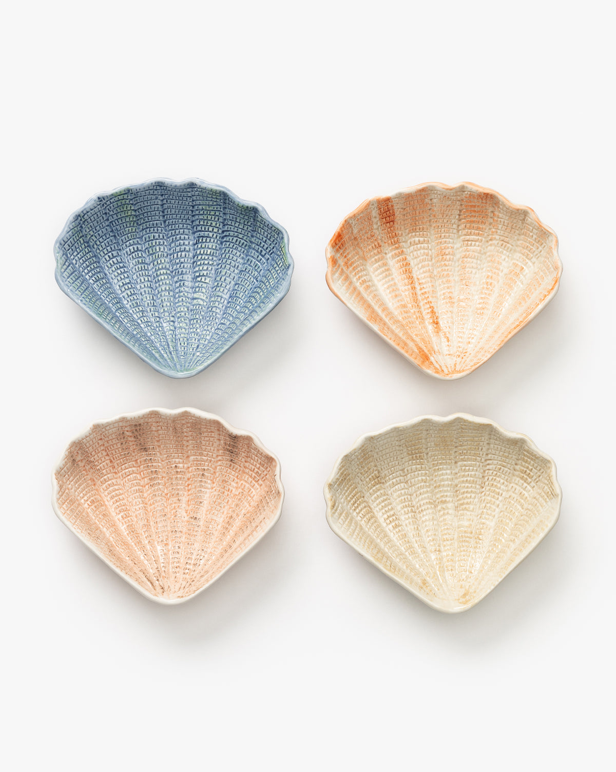 The Aurelie Shell Shaped Bowls (Set of 4) features pastel blue, orange, pink, and cream stoneware bowls arranged in a grid—ideal for bringing coastal charm to your table, by Vendixs