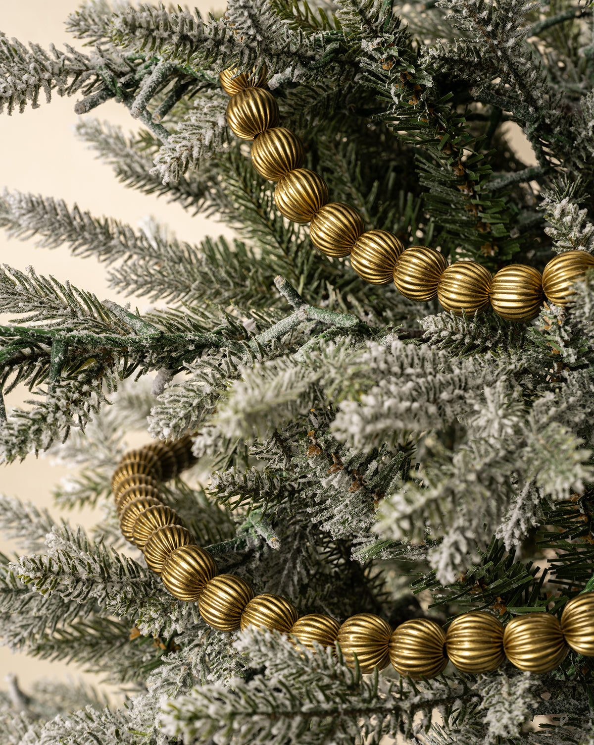 Textured gold beads shimmer among frosted green branches, adding a touch of classic holiday decor, by Vendixs