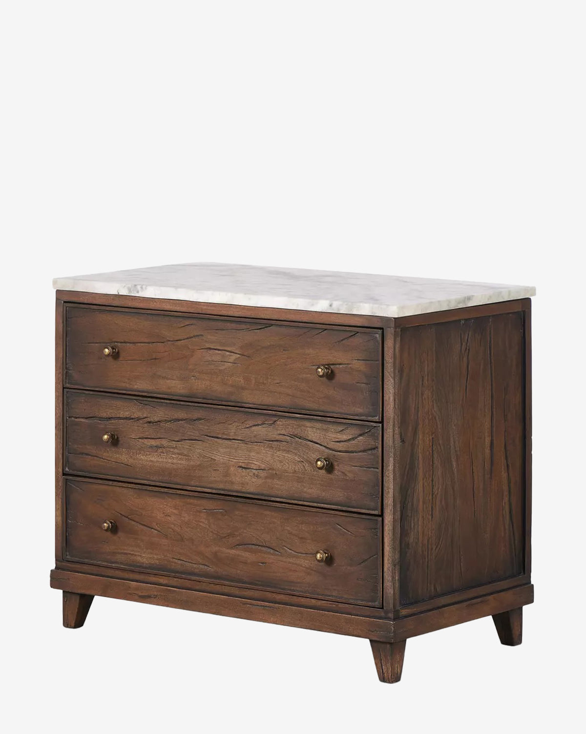 The Bettiga Nightstand features three drawers with brass hardware, a white marble top, and is crafted from antique reclaimed wood in a rich dark finish with visible grain, standing on four short angled legs by McGee & Co.