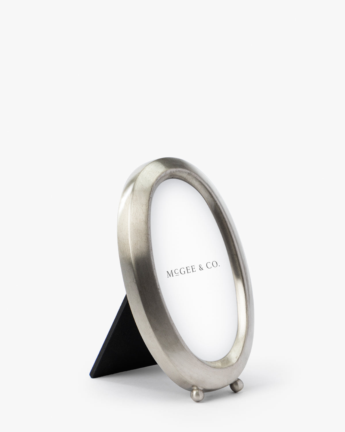 The Blanche Pewter Picture Frame features iron corners and a simple stand, displayed at an angle with a placeholder paper labeled Vendixs on a plain white background for a sophisticated look.