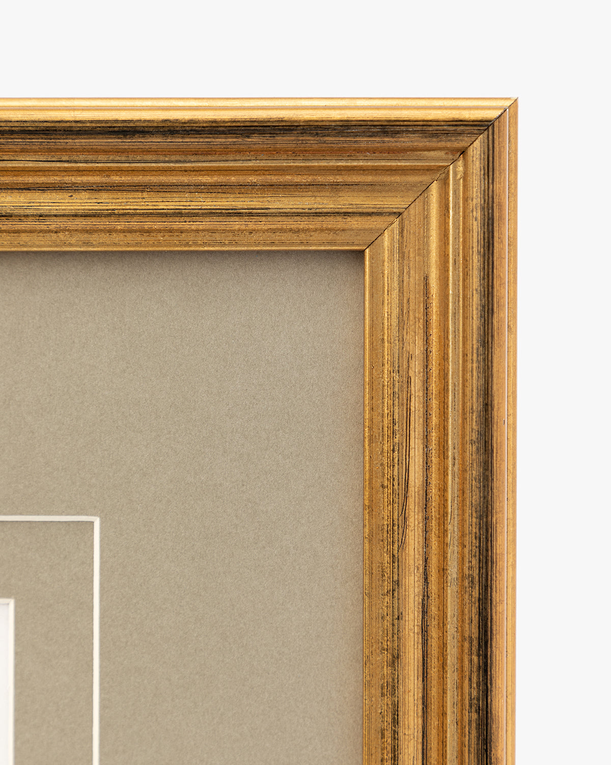 Close-up of the top right corner of an antique gold frame with a neutral beige matte, highlighting its textured, slightly worn finish—an ideal choice for displaying vintage wall art or petite florals like Blossoming Branch, by Vendixs