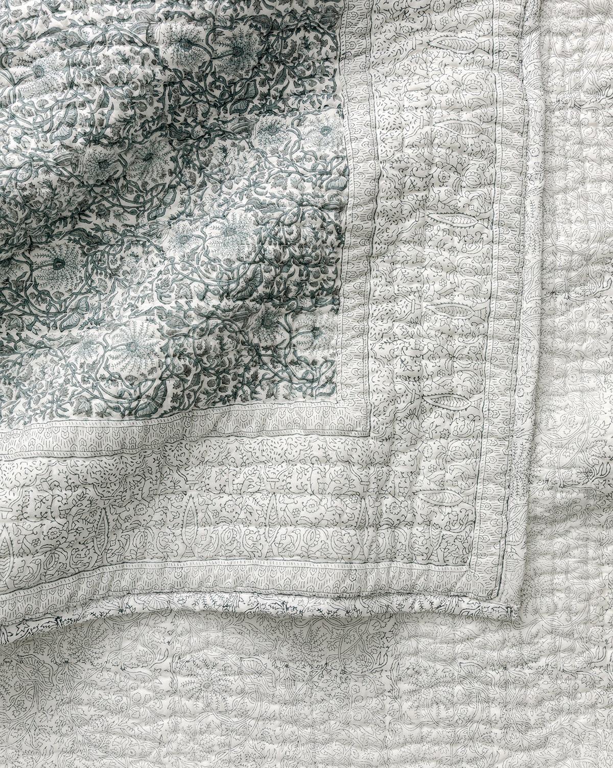 A close-up of the Blue Floral Block Print Quilt, showcasing detailed floral and geometric patterns in soft blue and white, with visible stitching and textured fabric—ideal for fans of artisanal bedding, by Vendixs
