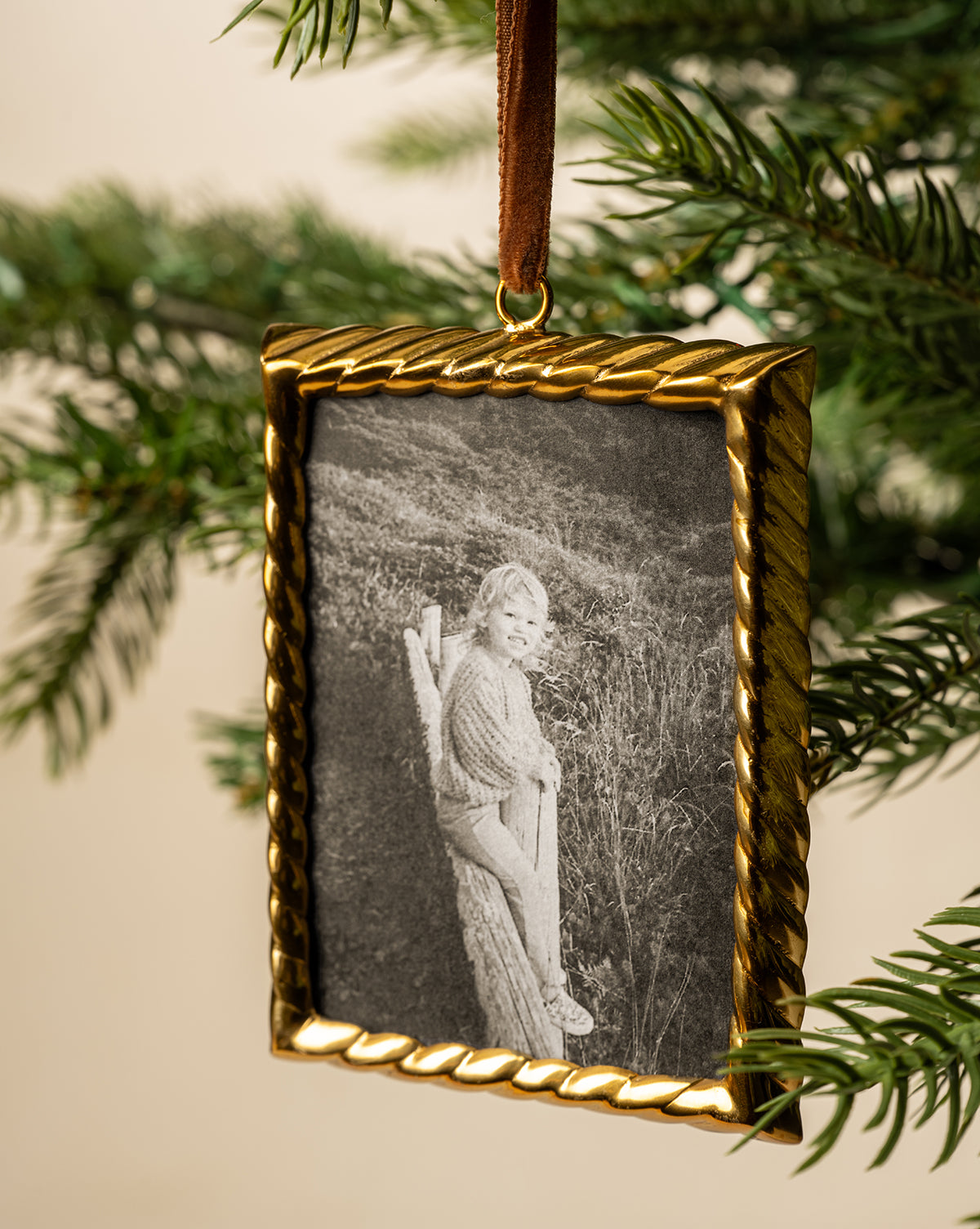 Hanging by a brown ribbon among green pine needles, this ornament brings warmth to your holiday decor, by Vendixs