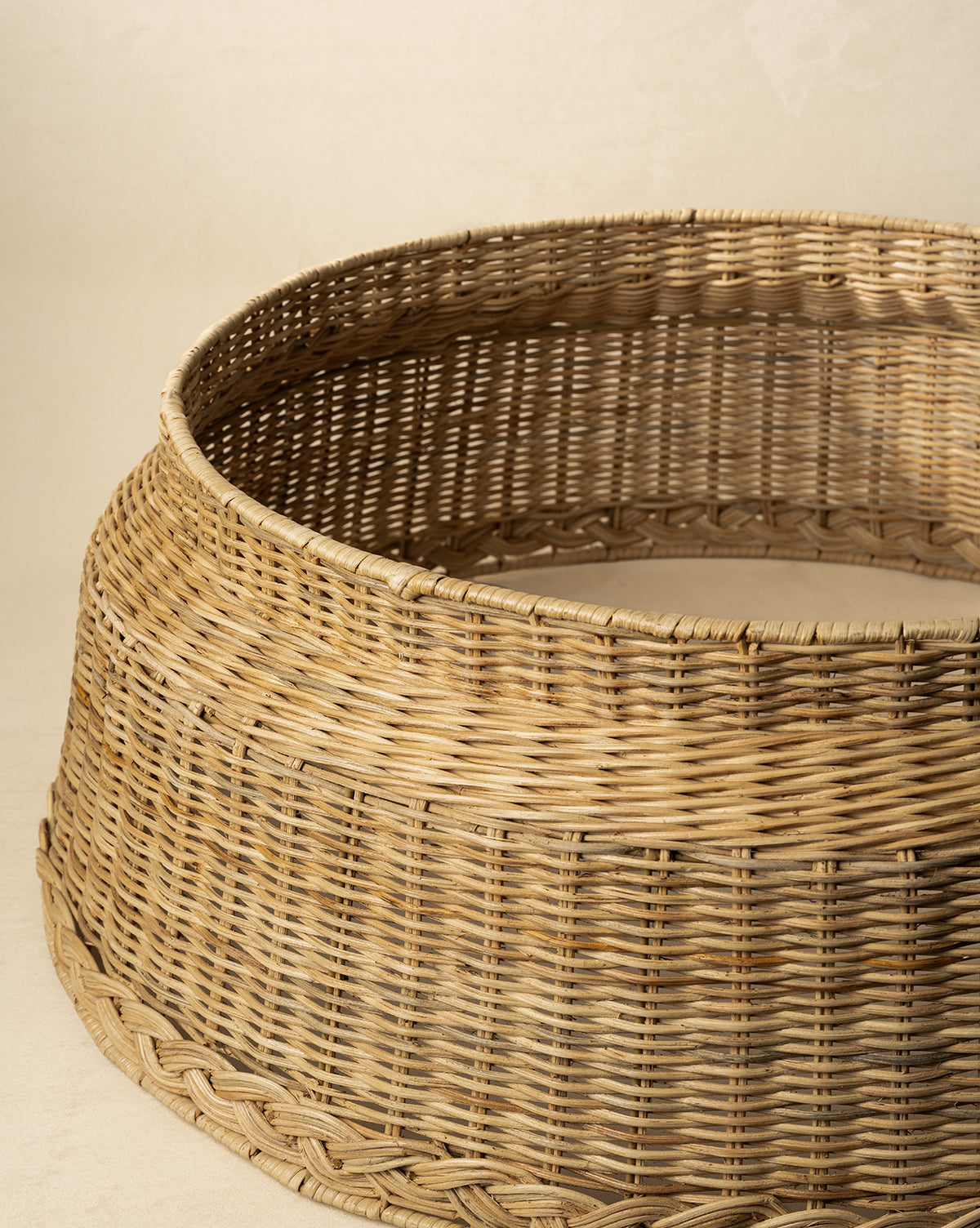 The Braided Wicker Collar features a round, woven design with a natural finish, wide base, and subtle taper, bringing classic charm to your holiday tree display against neutral décor, by Vendixs