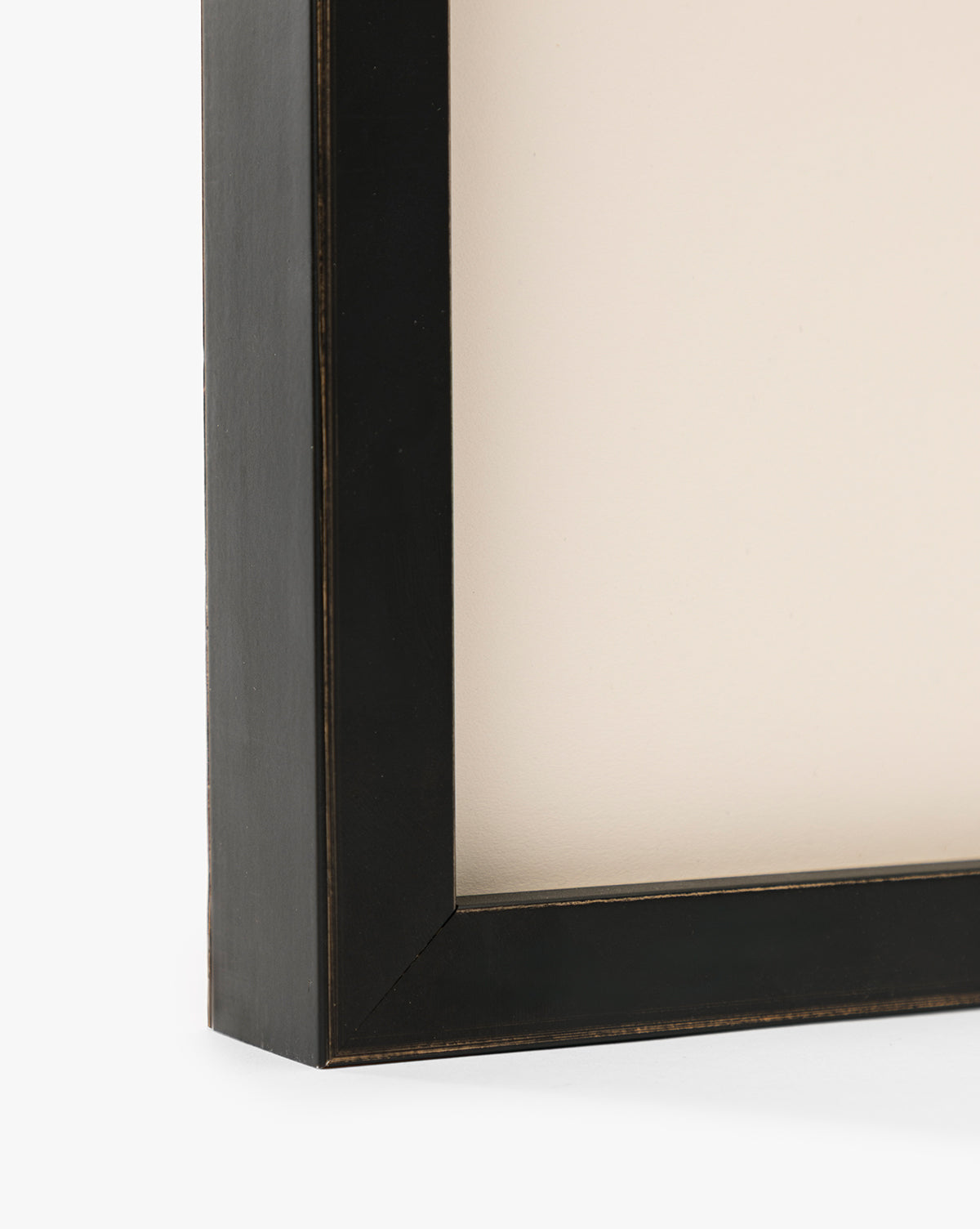 Close-up of the corner of a black, rectangular frame with a beige background, highlighting its modern edges and thickness—an ideal way to display Bright Horizons by Donna Thomas as stunning giclée print wall art, by Vendixs