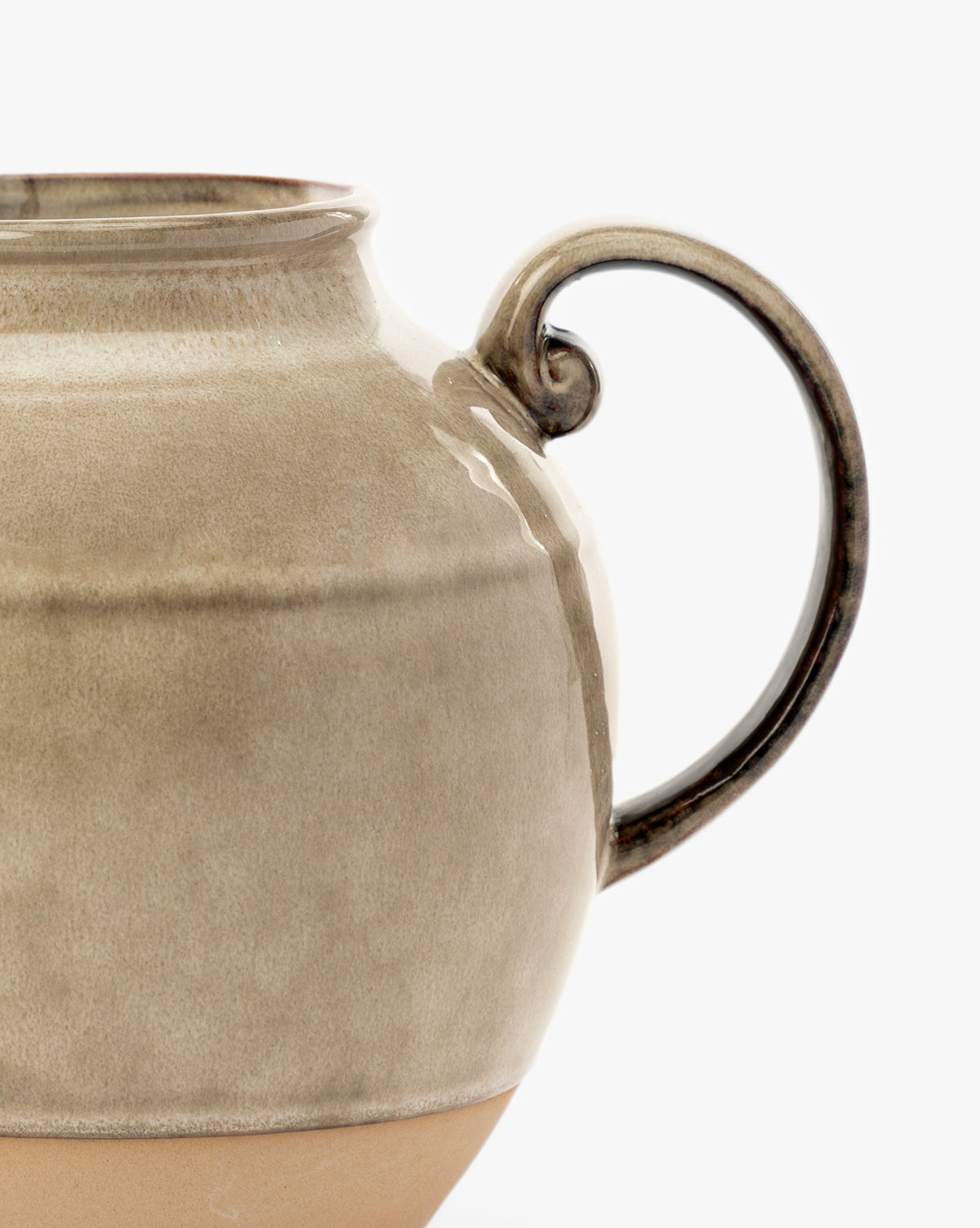 Close-up of a beige ceramic mug with a rounded body and looped handle, set against a white background—perfect for kitchen styling when paired with your Brown Stoneware Pitcher, by Vendixs Only half of the mug is visible in the image.