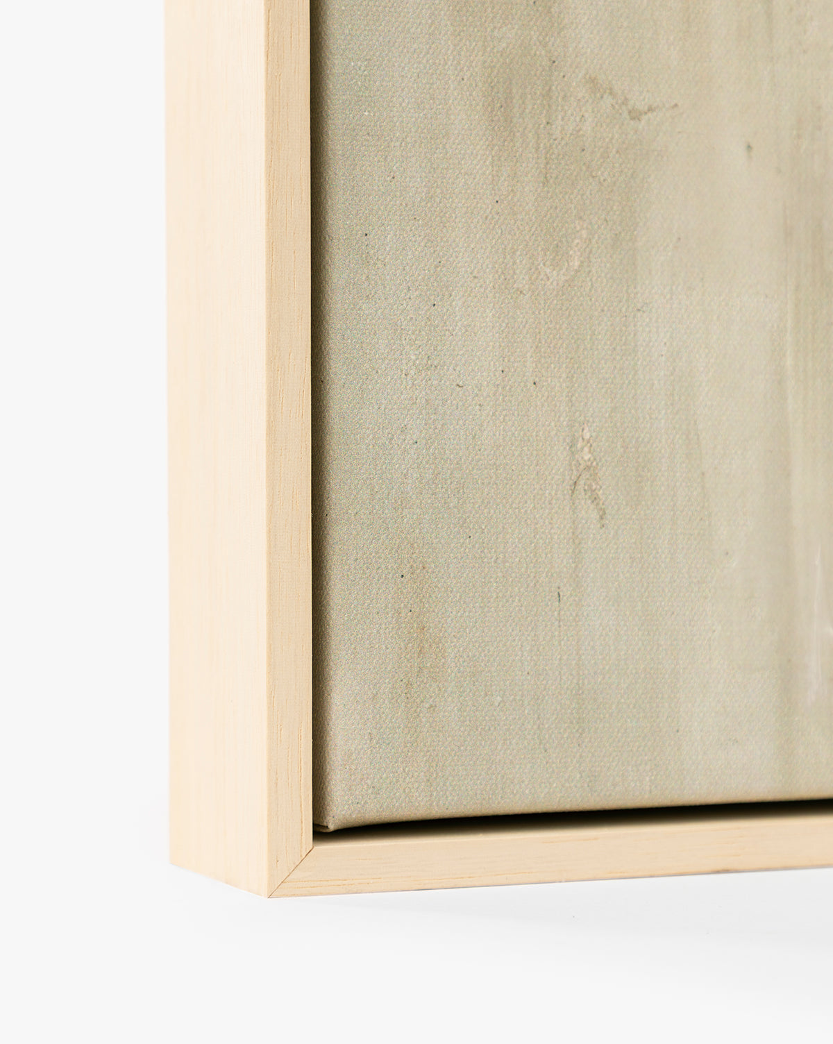 Close-up of the corner of the Brushes in Neutral light wood picture frame with canvas inside, showcasing the texture of neutral canvas art and the smooth frame set against a plain white background, by Vendixs