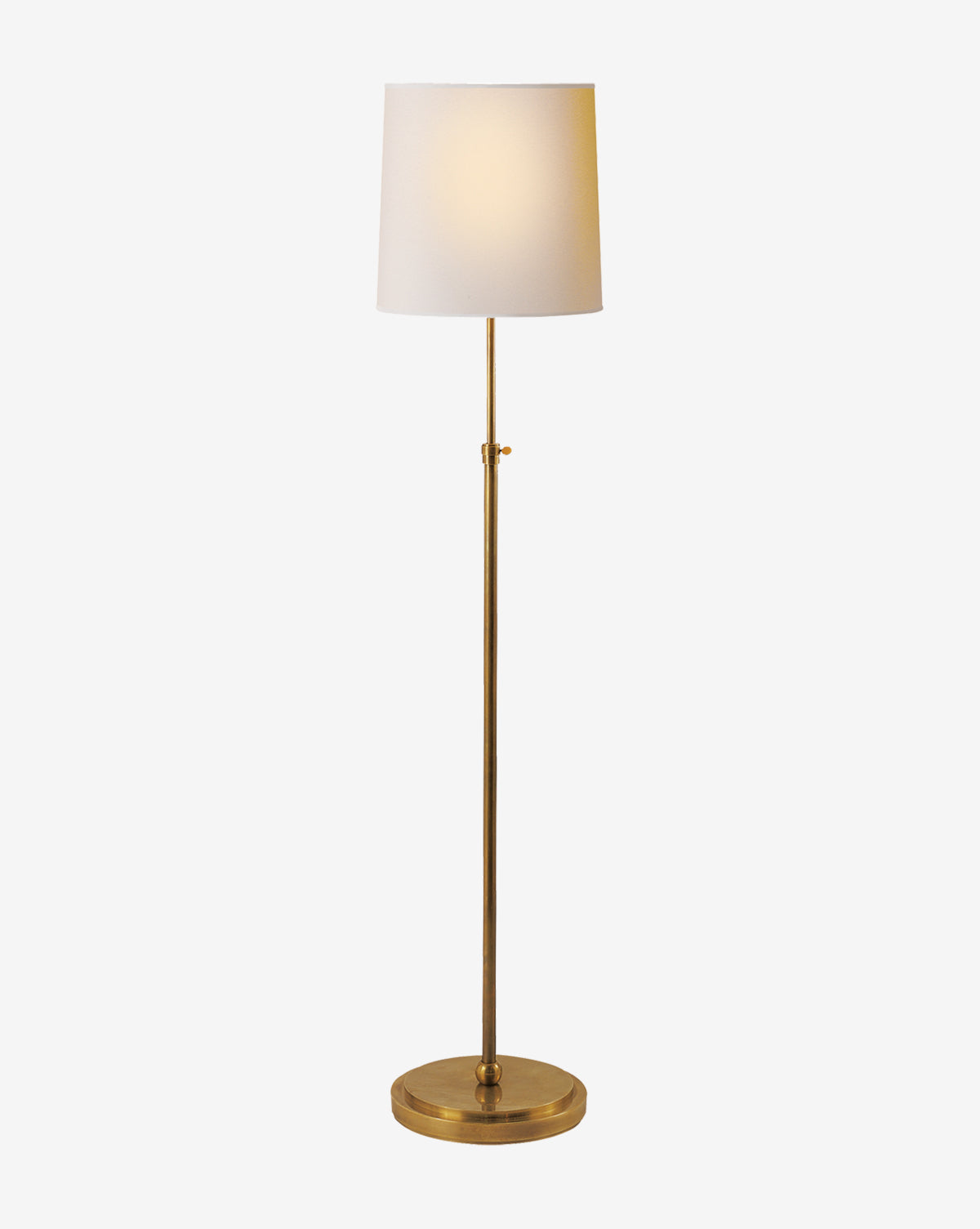 The Bryant Floor Lamp boasts a brass stand and round base with a white linen shade, providing a warm glow. Its simple elegance makes it ideal for contemporary interiors, by Vendixs