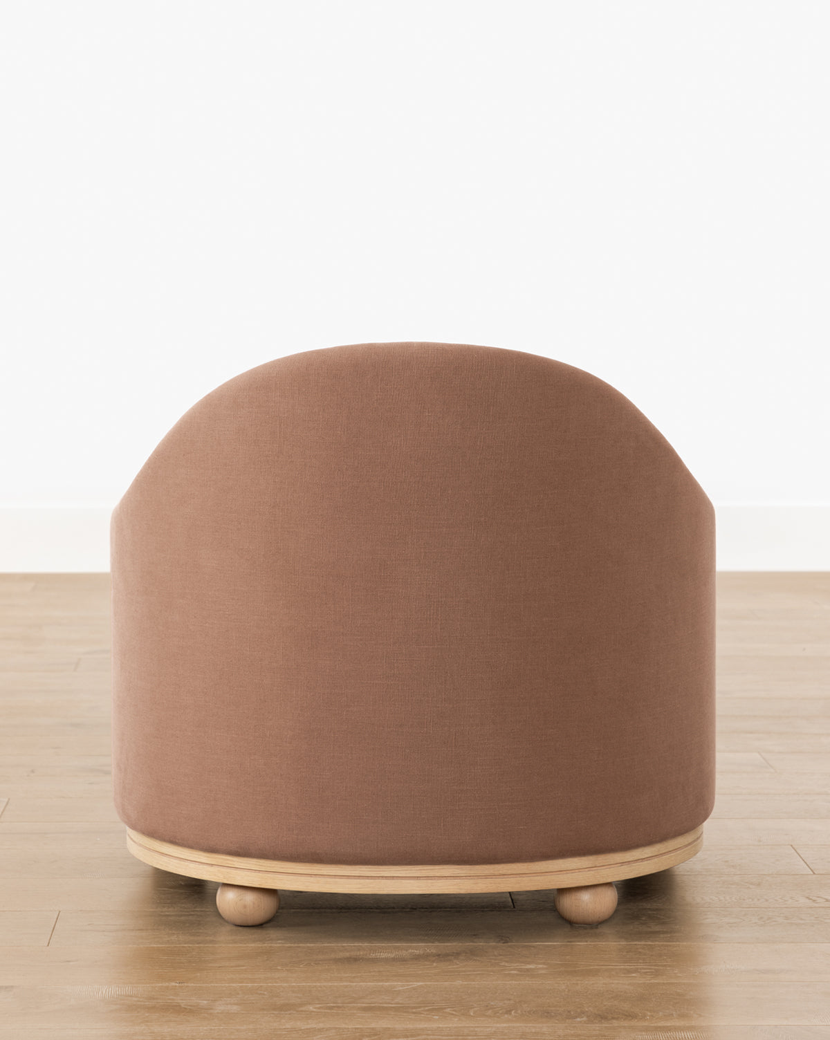 The Bunnell Lounge Chair (Ready to Ship) features a rounded, modern-traditional design with muted pink upholstery, a light wood base, and small round feet—perfect for any space with its clean lines and timeless appeal, by Vendixs