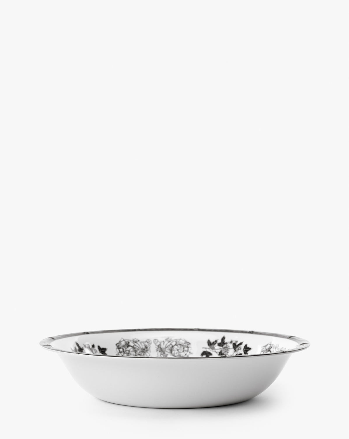 The Calanthe Melamine Serving Bowl features vintage-inspired black floral designs on white, a silver rim, and is shatter-resistant, making it perfect for elegant displays, by Vendixs