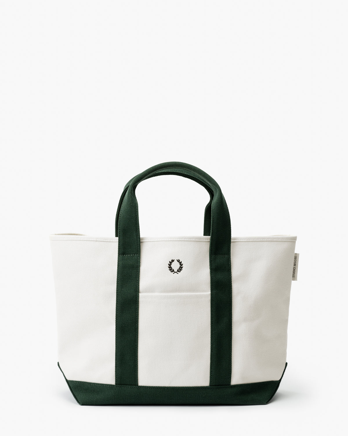 The Canvas Laurel Tote features a white canvas body with dark green handles and trim, plus a small black laurel wreath logo on the front—ideal for everyday use or fans of timeless Studio McGee style, by Vendixs