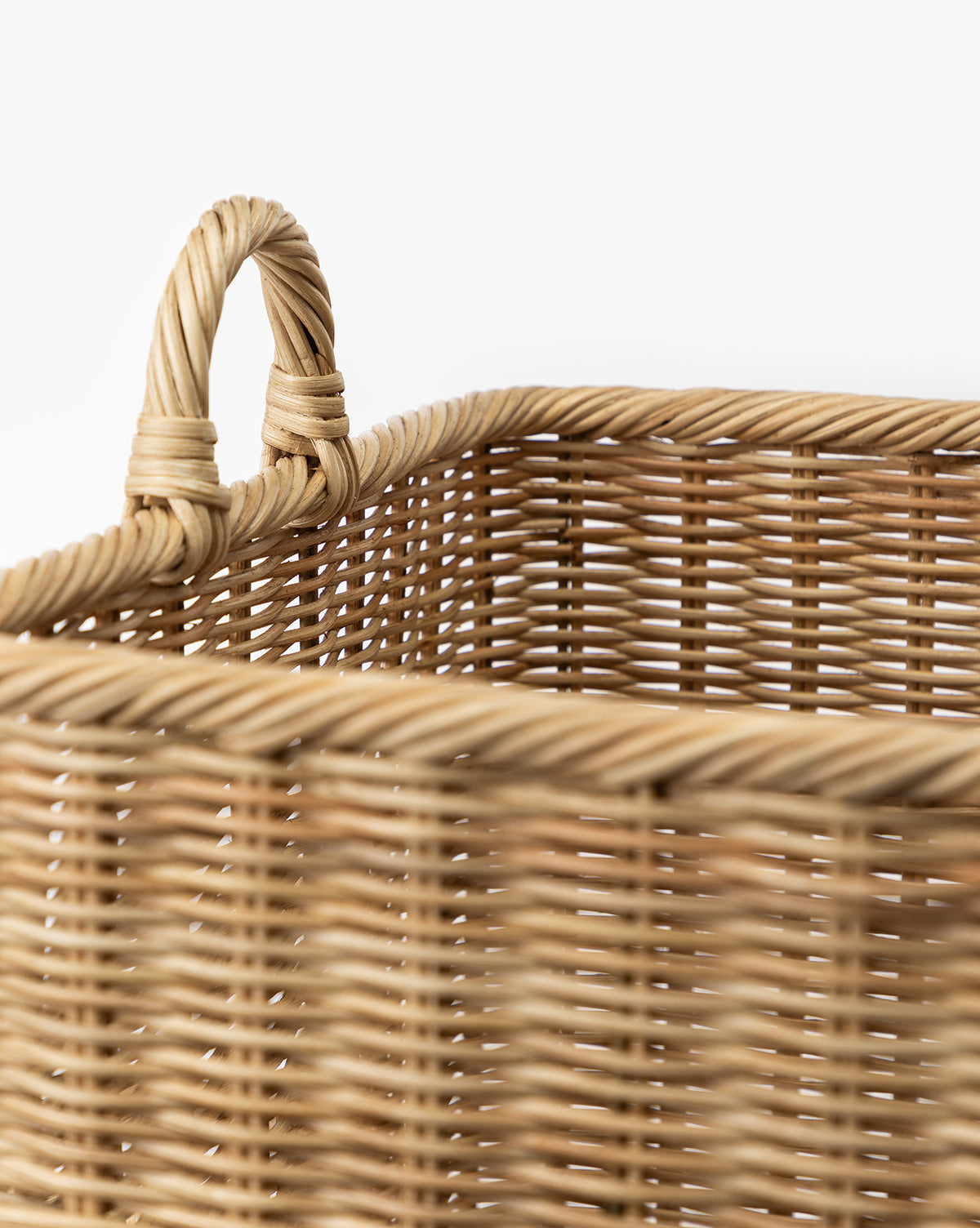 Close-up of the Chiara Laundry Basket, featuring a natural finish and sturdy handle, highlighting the detailed woven fiber texture and pattern against a plain white background, by Vendixs