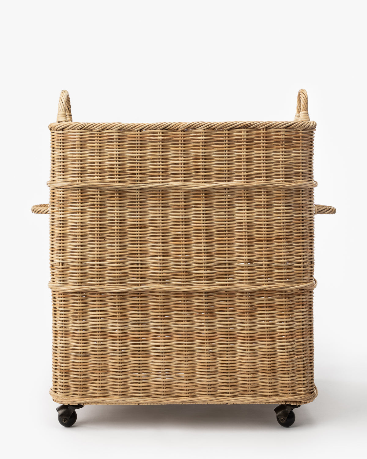 The Chiara Laundry Basket is a square, natural-finished wicker basket with side and top handles and four black caster wheels, perfect for rolling through your laundry room. Shown against a plain white background, by Vendixs